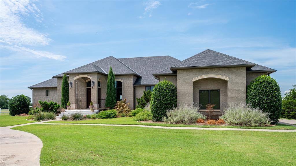 Timeless Elegance on 4 Acres, in Town! Discover classic sophistication thoughtfully blended with modern luxury in this private Brent Gibson–designed estate. Encompassing over 6,000 square feet, this residence boasts 5 bedrooms, 4 full baths + 2 half baths, 3 expansive living areas, a private study, 3 dining spaces, & 4 garage bays, with each space thoughtfully designed for both entertaining & quiet, comfortable living. From the moment you step inside, the grand open floor plan draws you in with a dramatic living room featuring soaring vaulted ceilings, rich custom built-ins, a custom stacked stone fireplace, & walls of glass that frame absolutely sweeping views from the veranda. The formal dining room is crowned with an exquisite custom ceiling that sets the stage for unforgettable gatherings. The gourmet kitchen is a chef’s dream featuring luxurious granite countertops, an oversized island with a 5-burner gas cooktop, a breakfast bar, walk-in pantry, & premium stainless steel appliances, including a built-in KitchenAid refrigerator/freezer. The private owner’s suite is a spa-worthy sanctuary, offering a spacious bathroom with dual vanities, a gorgeous walk-in shower, a Jacuzzi tub, & a wrap-around walk-in closet. An additional main-level suite with a private bath and walk-in closet provides ideal accommodations for guests or a second primary. The walk-out basement is designed for leisure & entertainment, boasting a home theater, kitchenette with bar seating, an expansive game room, interior saferoom/storm shelter, & 3 additional bedrooms with 2.1 baths. Step outside to take in the stunning panoramic sunsets from the expansive porches. Each season brings its own magic, from vibrant fall colors to the enchanting snow globe effect of winter. Updates include: Roof 11/22, HVAC X2 8/22, water heater 7/25, Pella windows & sliding doors, double ovens, microwave, refrigerator, dishwasher, water softener, reverse osmosis, & more! Call today for your private showing.