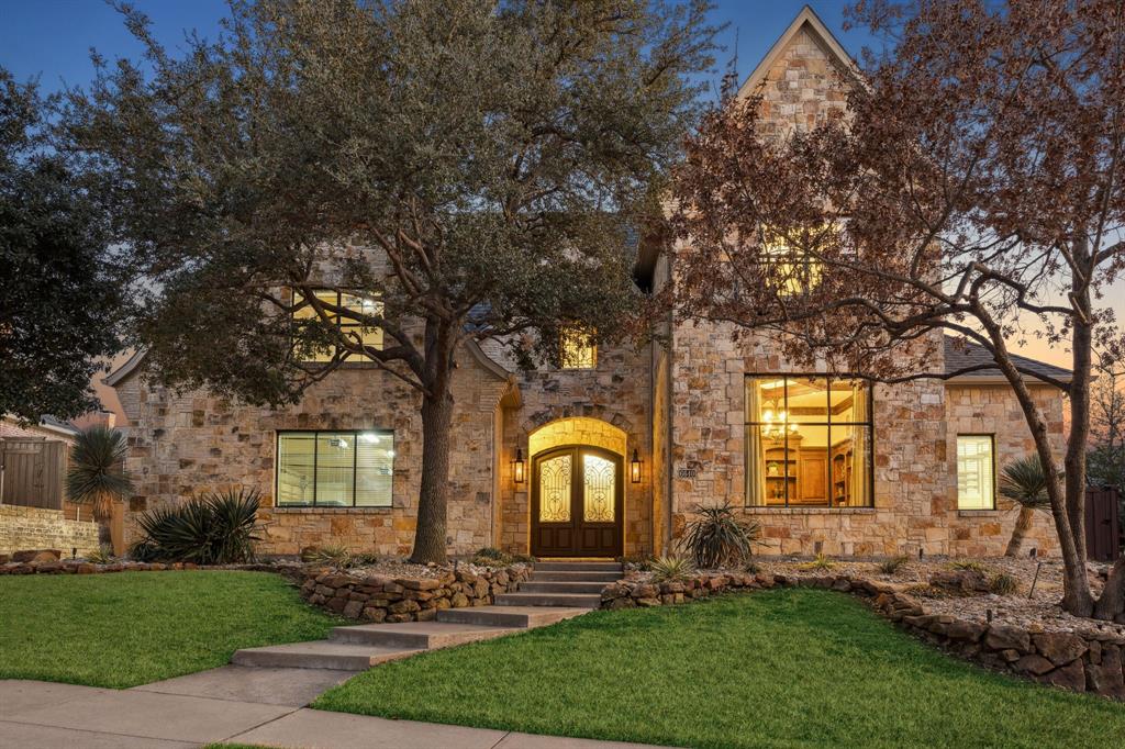 Spanning 5,731 square feet, this Lonnie Gray custom estate home blends impressive scale with warmth and everyday livability. With 4 bedrooms, 4.5 baths, and a 3-car garage, the home is thoughtfully designed for both grand entertaining and comfortable daily life. Located in the desirable Shoal Creek community, residents enjoy scenic jogging trails and tranquil neighborhood ponds. Just minutes from Grandscape and Legacy West, the property offers convenient access to premier shopping, dining, and entertainment while preserving a sense of privacy and retreat. A dramatic entry sets the tone with soaring ceilings, heavy crown moldings, rich hardwood floors, and a wall of windows that fills the space with natural light. The private study features custom built-ins, and the formal living room showcases a chandelier that electronically lowers and raises for effortless maintenance. Two staircases frame the home’s well-planned layout, which includes formal living and dining rooms, a private den, and dedicated media and game rooms. The result is a floor plan that feels both expansive and inviting. The kitchen is designed for those who love to cook and host, appointed with a Sub-Zero refrigerator, double ovens, a 6-burner gas range, dual sinks, and generous prep space, cathedral and beamed ceiling with upper and lower cabinet lighting. A wet bar and three fireplaces add warmth and character throughout. Outdoors, mature trees and lush landscaping create a private setting. The backyard is built for entertaining, featuring a sparkling pool and spa with waterfall, an outdoor firepit, built-in BBQ, multiple seating areas, and a turf play space. Gas lanterns at the front of the home provide a timeless and welcoming touch. This is a rare opportunity to own a home that delivers presence, comfort, and refined craftsmanship at every turn.