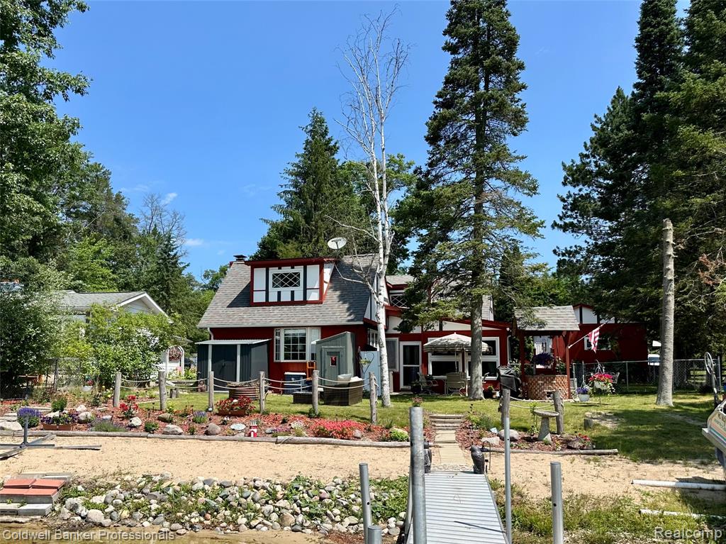 Welcome to your dream lakefront retreat! This custom-designed home offers over 70 feet of beachfront, on the highly sought-after all-sports Chain Lake. Perfect for relaxing weekends, boating, swimming, fishing, & year-round living, this property combines charm, functionality, & stunning views. The home is beautifully landscaped with country charm & located just down the road from thousands of acres of federal land perfect for hiking, hunting, and trail riding! This home has been custom designed throughout with thoughtful details in every room. Bright & airy kitchen w/Corian counter tops, appliances include the custom dishwasher. Spacious dining room with hardwood floors, Cozy living room featuring hardwood flooring & a classic wood-burning fireplace. Main floor primary suite w/private bathroom. Transitional office space is perfect for doing a little work while on "vacation". Large family room w/custom fireplace, bay window, & built-in window seat—offering stunning lake views, The Custom built-in shelving adds style & lots of storage. Beautiful wood staircase leading to two large upper bedrooms—both with lake views, large closets, & a full bath. Three-season room w/panoramic lake views opens to a lovely patio for outdoor entertaining. Exterior home features include a Private dock ready for your boat and water toys, Unique wood-fire BBQ with wishing well design, Fully fenced yard, Multiple storage sheds, 2-car garage with plenty of space for vehicles & all your lake gear. Additional features include Fresh paint & updated flooring throughout, First-floor laundry, Efficient mini-split units for year-round heating & cooling, & Back-up generator for peace of mind. Whether you're looking for a full-time residence or a seasonal getaway, this property is a rare blend of lakefront living & custom craftsmanship. Don’t miss your chance to own this one-of-a-kind home on the water, schedule your private showing today! Sale is subject to Seller finding another home within 30 days.