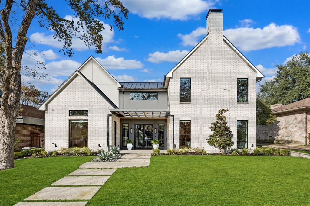 An Architectural Masterpiece by 5West Homes Step into a home that feels less like a residence and more like a curated exhibit—where every detail is intentional, elegant, and worthy of admiration. This stunning showcase by 5West Homes is a modern gallery of craftsmanship, thoughtfully designed to elevate daily living into an art form. White oak hardwoods stretch throughout the main level like refined brushstrokes, guiding you past professional-grade appliances, designer lighting, and a kitchen anchored by a sculptural, oversized working island. Floor-to-ceiling steel-framed windows and museum-finish walls transform natural light into an artistic medium, framing the treetops, pool, and outdoor living areas as ever-changing works of art. The floating staircase alone could be the centerpiece of a museum—light, architectural, and breathtaking. It rises beside a dramatic two-story wall of glass overlooking the pool, fire-pit lounge, and alfresco dining terrace. The grand front walk-up with double doors sets an immediate tone: this is a home meant to impress. Downstairs, the private office and guest suite offer elevated comfort, while upstairs hosts four additional bedrooms—each with its own adjacent full bathroom—culminating in a secluded primary sanctuary with vaulted ceilings and serene treetop views. A spacious upstairs utility room complements the large downstairs mudroom with its own utilities, ensuring beauty and function exist in equal measure. The living and dining spaces are flanked by a solid walnut wine display wall—an artistic installation in its own right—easily reimagined as a butler’s pantry for the entertainer. The marble-wrapped fireplace stands as a striking focal point, framed by windows that invite the landscape inside and create a sense of peaceful connection. A rear-entry oversized two-car garage preserves privacy while an additional front parking pad provides easy, quick access for guests or everyday convenience.