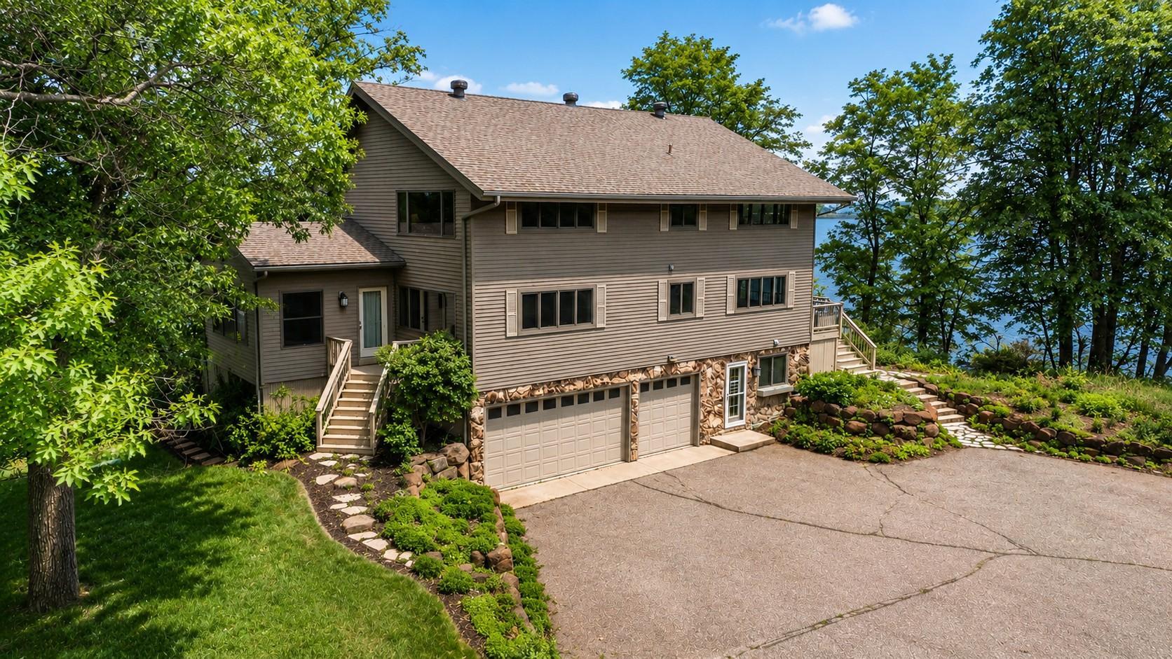 Your Own Private Clearwater Lake Peninsula! Rare opportunity to own 1.3 acres with an incredible 955 feet of shoreline and panoramic water views in nearly every direction. This one-of-a-kind property offers exceptional privacy, mature trees, beach area, and endless shoreline to explore.  The 4-bedroom, 3-bath home is thoughtfully designed to maximize lake views from nearly every room. The main level features a stunning great room with soaring vaulted wood ceilings, exposed beams, expansive windows, beautiful hardwood floors, and an impressive floor-to-ceiling stone fireplace. The spacious kitchen offers abundant custom cabinetry, a large center island, and seamless flow into the dining and living areas, making it ideal for entertaining. Just off the living space, the inviting porch provides the perfect spot to relax with a morning coffee, unwind with a book, or enjoy wildlife and water views.  The home offers a desirable floor plan with two bedrooms on the main level and two additional bedrooms on the upper level, providing comfortable accommodations for family and guests.  The walkout lower level is designed for recreation and gathering, featuring a second stone fireplace, spacious family room, game area, kitchenette with dining space, and direct access to the outdoors. Whether hosting weekend guests or enjoying lake life year-round, this level offers exceptional flexibility and entertainment space.  The 3-car tuck-under garage with epoxy floors provides ample storage, while the lakeside shed is perfect for toys and equipment. The shed was significantly improved in 2022 with a new septic and water line connection, the addition of a convenient 3/4 bathroom, and concrete floor for clean, functional storage.  With 955 feet of shoreline, panoramic water views, and the rare privacy of your own peninsula, this extraordinary Clearwater Lake property is a one-of-a-kind lakefront retreat.