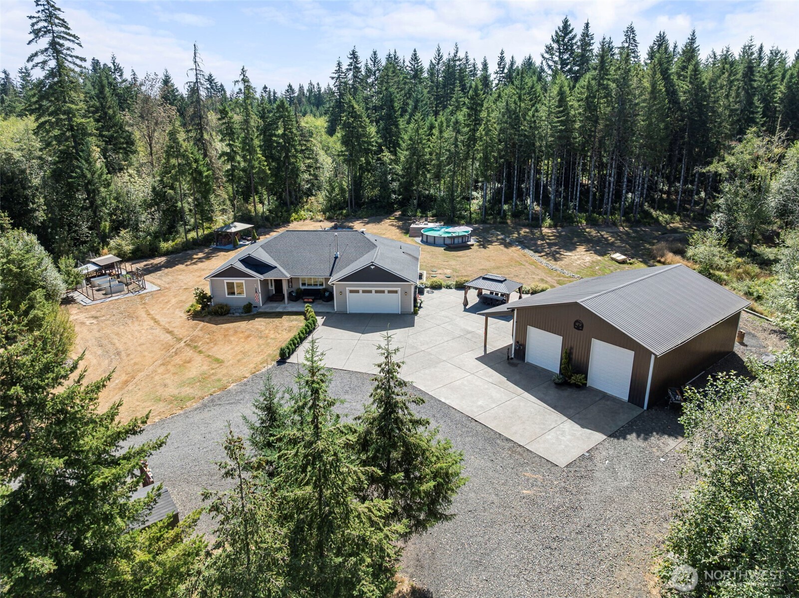 This beautifully maintained Logan Hill property offers the perfect combination of comfortable country living, recreation, and room to spread out! Situated on 9.8 flat, usable acres, this 2,178 sq. ft. home features an open-concept layout with vaulted ceilings, a desirable split-bedroom floor plan, 4 bedrooms, and low-maintenance vinyl plank flooring. The spacious kitchen offers quartz countertops, stainless appliances, and a walk-in pantry, while the primary suite includes a large walk-in closet and 5-piece bath.  Step outside and enjoy your own private retreat with a swimming pool, spacious back patio, fire pit areas, fenced garden with a chicken coop, and plenty of room for animals and outdoor fun. The 36'x48' shop is set up for both work and play with a pellet stove, TV and bar area, plus a 10'x48' covered lean-to currently used as a dog run. New concrete provides generous parking in front of both the home and shop, and two gated entrances offer convenient access to the property.  Explore miles of trails and motorcycle track winding through 25-year-old timber, right in your own backyard. Located on a quiet dead-end road with access to hundreds of acres of timber company land at the end of the road, this property offers a wonderful sense of privacy and room to enjoy the outdoors while still being conveniently located in the desirable Logan Hill area of Chehalis. The home also features a wood stove and is wired for a generator.