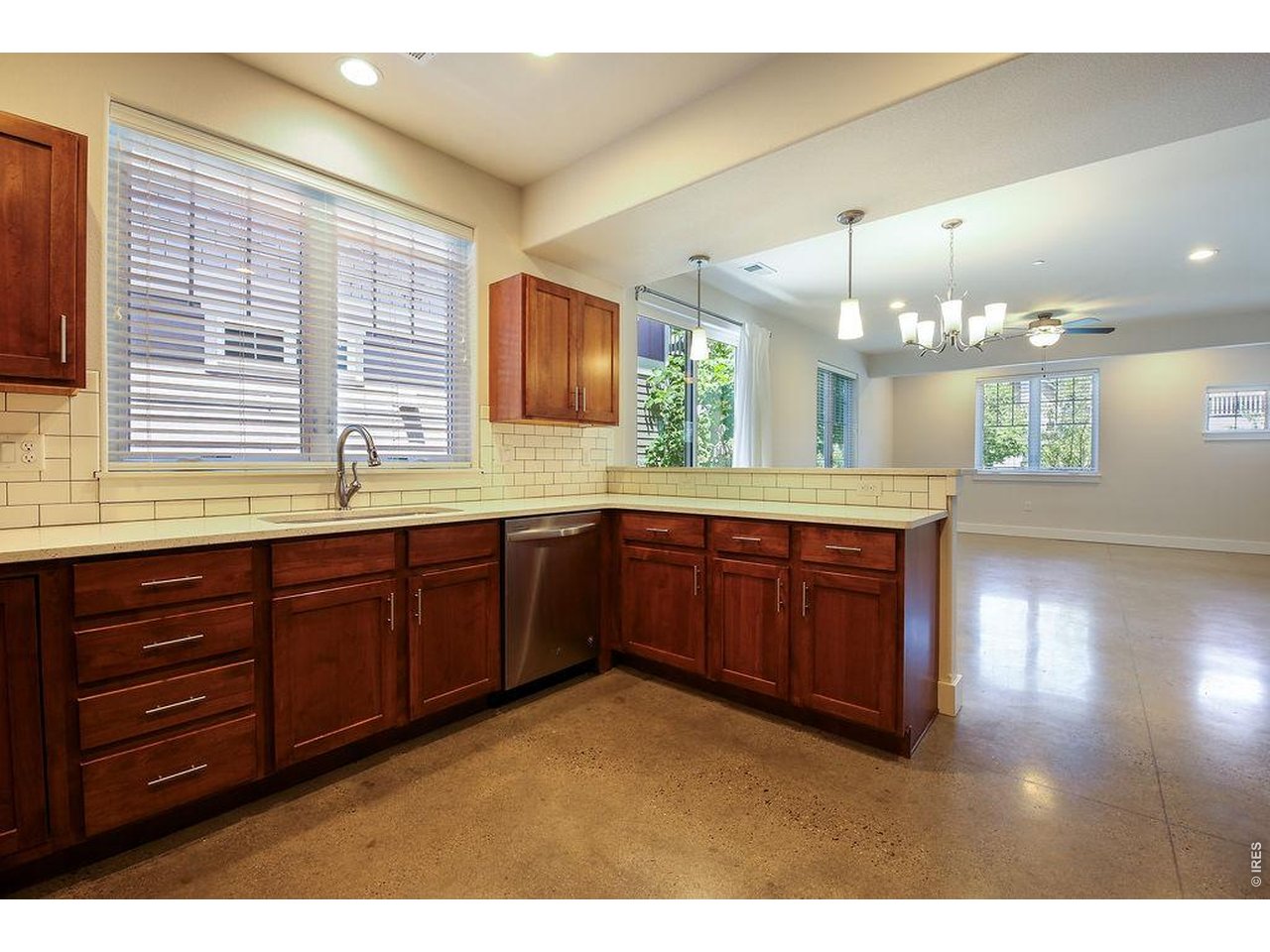 Modern, energy-conscious living meets flexible income potential. Built in 2017, this thoughtfully designed property features a primary 2-bedroom, 3-bath residence plus an accessory dwelling unit with its own full kitchen, laundry, and separate entrance - ideal for rental income, multi-generational living, guest quarters, or a house-hacking strategy. Inside, you'll find elevated finishes including quartz countertops, stainless steel appliances, high ceilings, and bright, efficient living spaces. The property is equipped with PV solar, geothermal heating and cooling, and an electric vehicle charger in the 21' x 19' garage, offering a compelling blend of comfort, sustainability, and long-term operating efficiency. Outdoor living is easy with a main patio and ADU balcony, while the HOA provides added convenience with common recreation/open area, trash, snow removal, and lawn care included with dues.