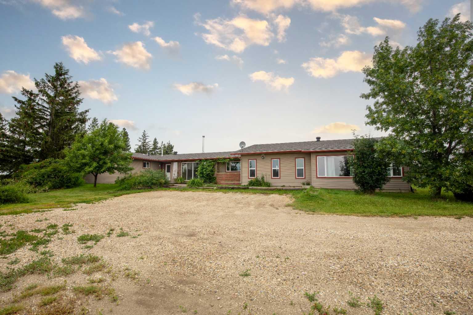 Welcome to this very large and versatile bungalow situated on 3 scenic acres just minutes from Grande Prairie on the west end of Richmond Hill, offering breathtaking mountain views and a nice size shop. Designed with large or multi-generational families in mind, this unique home features a total of 6 bedrooms and 3.5 bathrooms with an exceptional layout. Four bedrooms are located on one end of the home, while two additional bedrooms are situated on the opposite end with a separate living area, providing excellent privacy and flexibility for extended family or guest accommodations. The heart of the home is the large open-concept kitchen and living area, perfect for entertaining, complete with wood fireplace for added warmth and comfort. In-floor heating in a portion of the home provides additional year-round comfort. Numerous upgrades have been completed over the years, including siding, shingles, some windows, the furnace, paint, trim, interior doors, cabinets and finishing throughout, and the water well pump, offering peace of mind to the next owner. Outside, you'll appreciate the partially fenced 3-acre parcel, gravel driveway, outstanding mountain views, plumbed in natural gas BBQ and the large heated 30’ x 43’ shop that's ideal for hobbies, storage, or apply for a home occupation. Please note that the property includes a GP Networks tower and a Seacan, and the purchaser will be required to assume the existing lease agreement associated with the tower. If you've been searching for country living with space for the whole family, incredible views, and easy access to Grande Prairie, this property is one you won't want to miss.