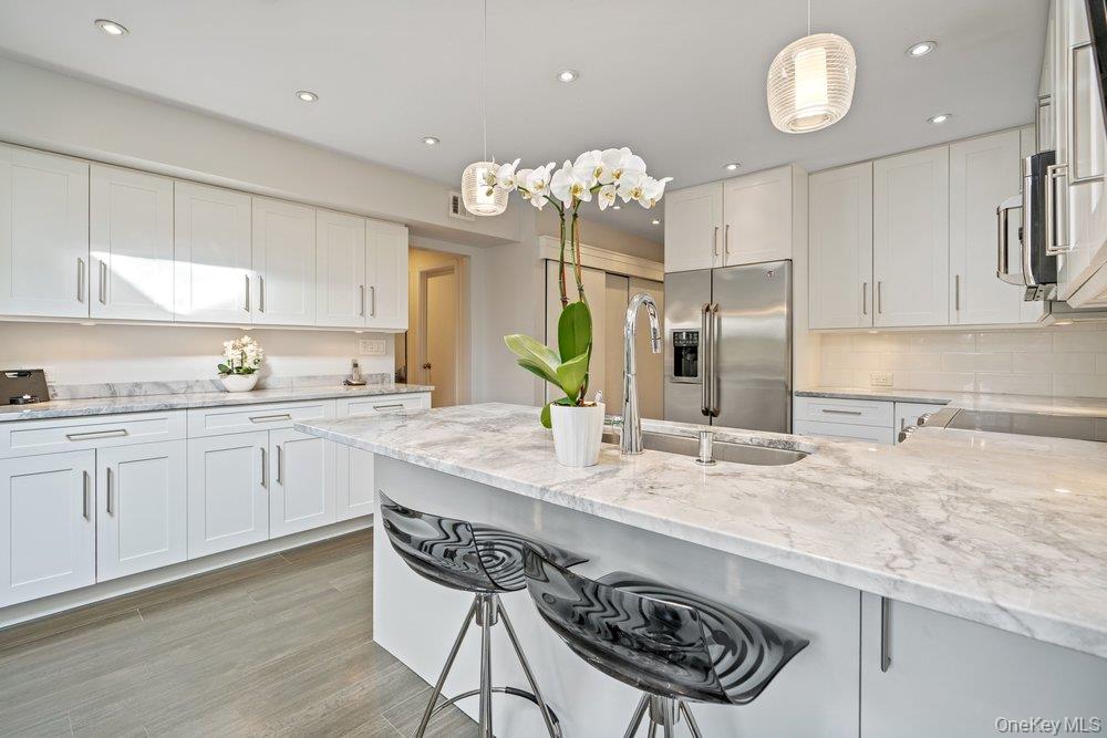 Welcome to this gracious recently renovated home.  Upon entering there are wood floors throughout the main level, wood burning fireplace as focal point in the Living and Dining Rooms.  All rooms on the main floor have sliders to an enclosed deck in with an expansive backyard.  The Kitchen, with laundry area, has white cabinetry, quartz counters tops, Breakfast Bar plus room for a table.  There's easy access from both the garage and the deck from this elegant Kitchen. The Living and Dining Rooms make it easy for entertaining as they flow from one to the other. Upstairs to the Primary Suite, with a dressing area, new bathroom with an expanded shower and walk-in closet.  The second bath, shared by the other two Bedrooms is also new, with quartz counters.  Both Bathrooms have windows since it's a end unit. Looking for a move-in condition home , then this is for you. Enjoy the year round amenities and security The Hamlet has to offer as this is a quickly moving market and properties like this, do not last for long.