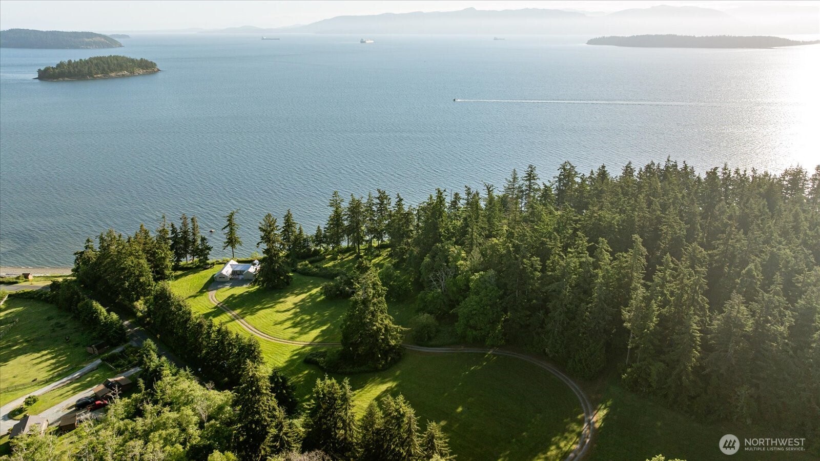 A Legacy Estate in the Making. This rare 65.5-acre private waterfront estate on Guemes Island (the quiet southern gateway to the San Juan Islands) offers 1,664 feet of shoreline & sweeping northern views across Padilla Bay to Bellingham, Mount Baker, the Cascade Mountains & beyond, all the way to Canada. Imagine your personal "state park” or a true village. Beyond the existing home, 5 approved 1-acre waterfront homesites are fully prepared for construction, each with power, utilities, & its own designated well already in place. A conceptual master plan and architectural drawings (including barn) provide a ready blueprint for multi-generational living.   At the center is a beautifully reimagined 2,068 sq. ft. home (3 bed, 1.75 bath) featuring vaulted ceilings, large stone fireplace, cozy family room off the kitchen with a wood-burning stove, reclaimed wood flooring & walls of glass that seamlessly frame the water. The remaining nearly 60 acres is comprised of protected seasonal stream and bluff easements, & more than 26 acres of woods, pasture, & trails awaiting your orchards, horses, or peaceful morning walks to the beach. Clamming, crabbing & fishing are at your doorstep, with community beach access for all homes. Whether envisioned as a multi-generational compound,  personal secluded haven, or private corporate retreat, the entire property sits behind a single gated entry—just a five-minute ferry ride from Anacortes. Seven parcels. One extraordinary canvas.