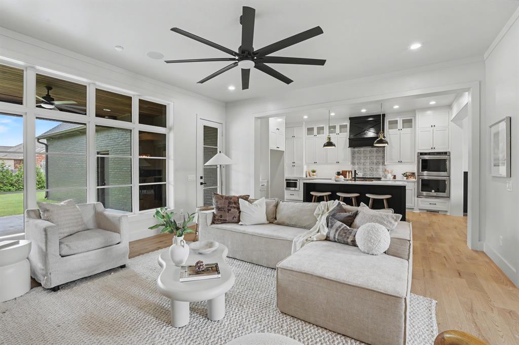 Welcome to Carrington Place, where modern farmhouse style meets spacious, thoughtfully designed living. From the moment you arrive, the beautiful landscaping and inviting covered front porch create the perfect first impression—just waiting for a porch swing and your morning coffee. Inside, a grand entry opens to a light-filled living room where a sleek linear fireplace and custom built-in bookcases create a stunning focal point. The open layout makes entertaining effortless, flowing into a chef’s kitchen featuring KitchenAid appliances, a farmhouse sink, oversized island, gas cooktop, double ovens, and a beverage bar with a wine fridge. The primary suite is a peaceful retreat with oversized windows that flood the room with natural light. The spa-inspired en suite offers abundant storage, an oversized walk-in shower, and an impressive walk-in closet that conveniently includes a built-in safe room for added peace of mind. Upstairs, you’ll find the perfect hangout with a second living area, wet bar, and a private guest suite with its own en suite bath. Every detail was designed with everyday living in mind, from the oversized laundry room with built-in storage and utility sink to the convenient mudroom that keeps life organized. Step outside and you’ll discover one of the home’s best features—a large covered back patio that’s ready for everything from football Saturdays to summer cookouts, complete with direct access to a guest bath for added convenience. Living in Carrington Place means more than owning a beautiful home. Enjoy neighborhood ponds, parks, a clubhouse and pool, pavilion, basketball court, and baseball/soccer field—all just minutes from everything Norman has to offer. Homes with this combination of style, space, and amenities don’t come along often. Schedule your private showing today!