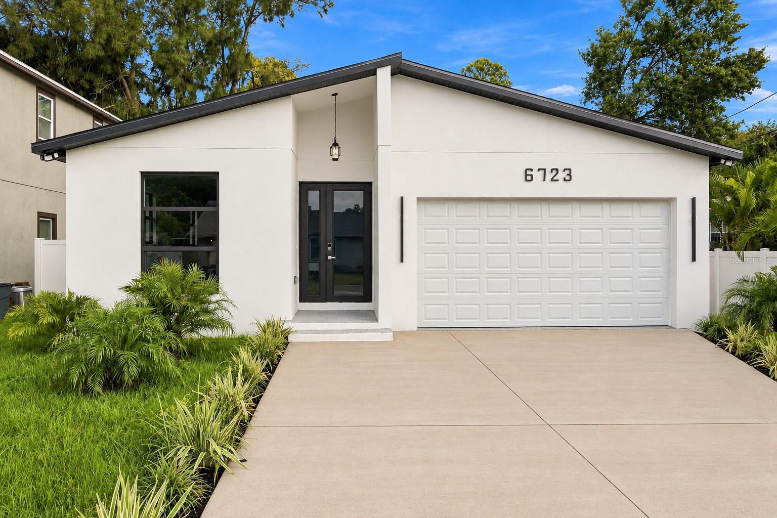 Modern style, beautiful finishes, and inviting spaces come together in this eye-catching home. A bright, open layout welcomes you inside, where polished marble-look tile flooring and a soft neutral palette create an elegant feel throughout. The kitchen is a standout, featuring a waterfall island, two-tone cabinetry, a beautifully coordinated backsplash, stainless steel appliances, and a built-in oven and microwave. Whether hosting guests or enjoying a quiet evening at home, the connected kitchen and living spaces make gathering easy. The bathrooms add a refined touch with floating vanities, glass-enclosed showers, and distinctive fixtures. Sliding glass doors bring in natural light and provide access to the backyard, while a dedicated laundry room and two-car garage add everyday convenience. With appealing curb appeal and a cohesive contemporary design, this home deserves a closer look. Schedule your private showing today!