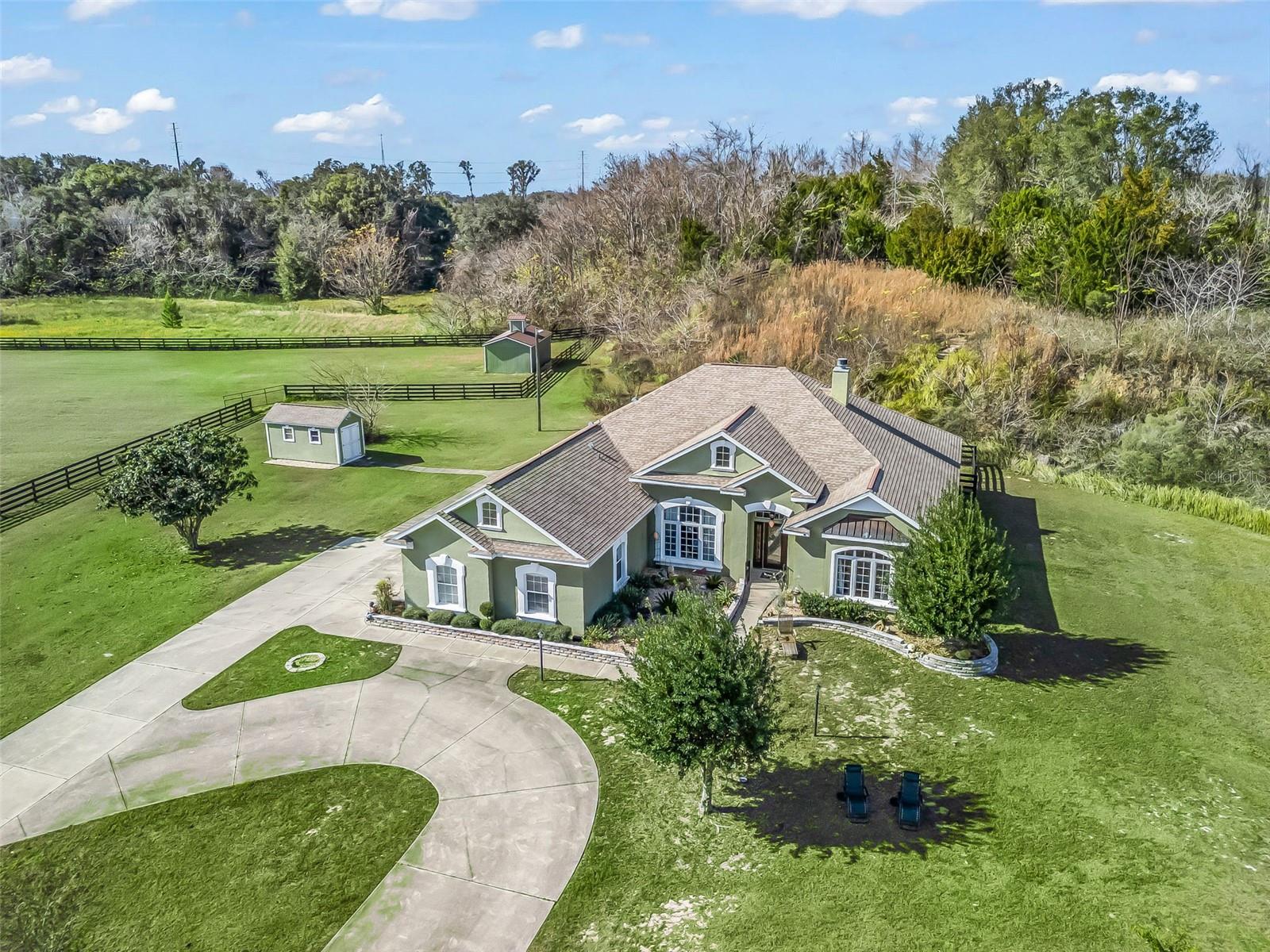 A rare equestrian gem offering privacy, acreage, and a truly unforgettable setting. Nestled at the end of a quiet cul-de-sac in a sought-after equine community, this lovely equestrian estate is located in the heart of the Horse Capital of the World. The inviting home offers 4 spacious bedrooms and 3 bathrooms, including a den/office, a cozy living room with fireplace, and a light-filled dining room. The oversized eat-in kitchen boasts abundant counter space and opens to a gorgeous enclosed sunroom, perfect for relaxing or entertaining. Enjoy your morning coffee on the screened-in porch overlooking a very private and serene backyard. The gated property features a side-entry garage, fenced pasture, and a convenient 2-stall barn—ideal for keeping your horses close to home. Set on 5.65 acres and zoned A-3, this property offers a truly unique, one-of-a-kind feature: the backyard backs up to an old quarry. A staircase leads to your own hilltop retreat, perfect for picnics  or evenings spent under the stars. Ideally located among beautiful horse farms, just 20 minutes from the World Equestrian Center, 10 minutes from Majestic Oaks, and only 15 minutes from Downtown Ocala, this special property offers privacy, charm, and an exceptional equestrian lifestyle.