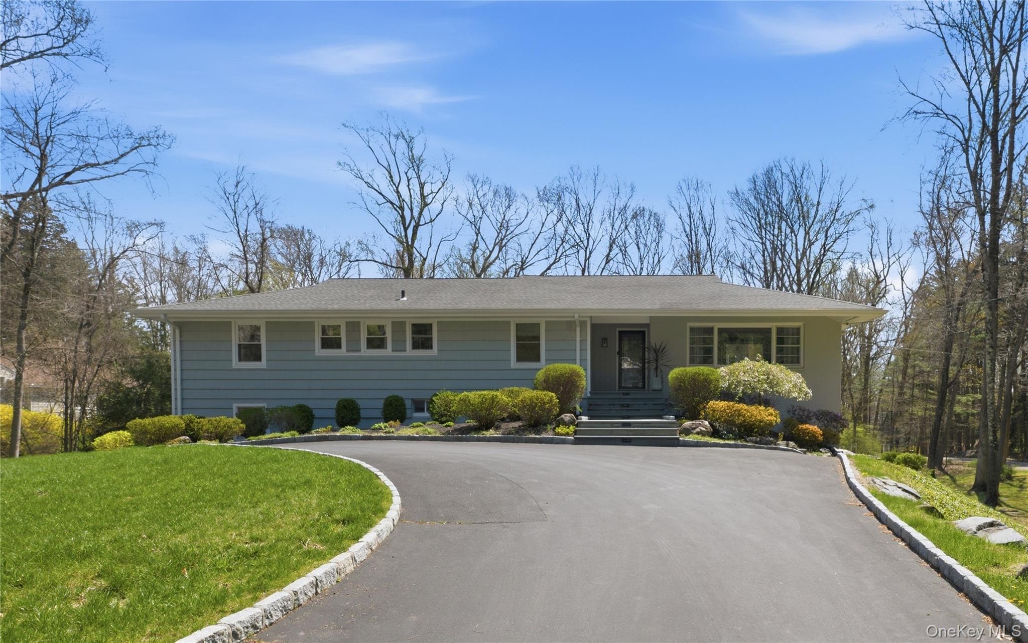 Welcome home to Windmill Farm in the heart of Armonk. This four-bedroom raised ranch is the perfect combination of comfort and elegance, where a beautiful circular driveway and extensive landscaping set the tone from the moment you arrive. Inside, the home features a light-filled family room off the kitchen with cathedral ceilings, creating a bright and inviting atmosphere. The kitchen flows seamlessly into a formal dining room detailed with a great inset ceiling and custom lighting, leading into a fabulous, highly decorated living room framed by a wall of windows. The lower level offers an amazing bar and private sauna, and a mudroom that walks out to the side driveway area where there is plenty of parking for your guests. Set on a private, fenced-in bi level acre, the backyard is an ideal space for sports or large parties, accented by custom exterior lighting. Experience the ultimate in style and privacy, all just a short distance from the The Windmill Club.