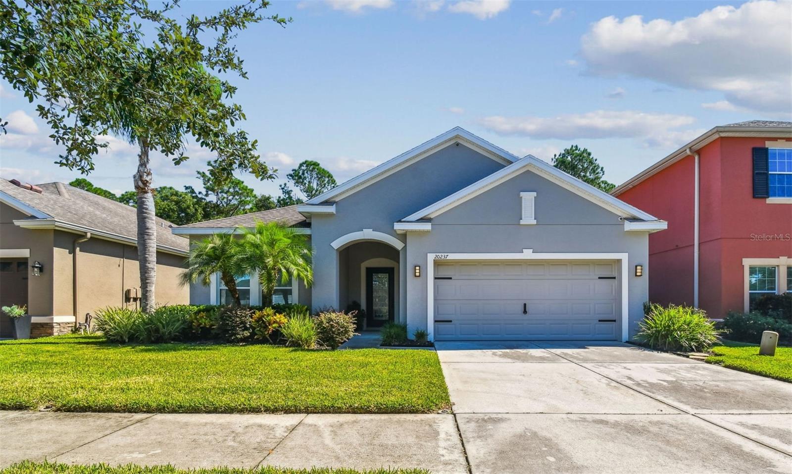 Welcome to this beautifully maintained 4-bedroom, 2-bath home with serene CONSERVATION VIEWS in the 24-hour GATED community of LIVE OAK Preserve in New Tampa. Step through the leaded-glass front door into a bright, open floor plan featuring 18” diagonal tile in the main living areas and custom craftsman touches throughout.

The kitchen was enhanced with refinished 42” solid-wood cabinets with crown molding, under-cabinet lighting, granite countertops, a large center island, wine rack, pull-out trash and recycling bins, a custom pantry and a built-in microwave shelf beneath a designer range hood. 
The SPLIT FLOOR PLAN offers spacious secondary bedrooms, two with carpet and one with cherry Pergo flooring. The owner’s suite features a LARGE WALK-IN CLOSET, garden tub, separate shower, dual granite vanities, resurfaced cabinetry, and a custom built-in wardrobe. Additional interior details include a barn door with soft-close feature, custom closet shelving, a built-in drop station with shoe cubbies and backpack hooks, gym flooring in one of the bedrooms, and garage storage racks with a workbench.

Step outside to enjoy PEACEFUL WOODED CONSERVATION views, vinyl fencing on both sides, a covered lanai, outdoor lighting, and lush landscaping, an ideal setting for your FUTURE BACKYARD OASIS. Exterior improvements include FRESH PAINT and custom, pre-cut hurricane plywood panels.

Other notable features include four exterior security cameras, SURROUND SOUND, Alexa thermostat, remote-controlled fans, and a RADIANT BARRIER ATTIC for improved energy efficiency.

Live Oak Preserve residents enjoy RESORT-STYLE AMENITIES including a grand clubhouse, Olympic-size pool with water slide and splash zone, heated spa, fitness center, playground, tennis, basketball, and volleyball courts. Zoned for Turner/Bartels K-8 SCHOOLS – MINUTES FROM YUR DOORSTEP, and close to Wiregrass Mall, Tampa Palms Golf & Country Club, Flatwoods Wilderness Park, AdventHealth Wesley Chapel, and Moffitt Cancer Center. Conveniently located near I-75, I-275, and I-4 with easy access to Downtown Tampa, Tampa International Airport, and Orlando.

Schedule your private showing today and experience the best of New Tampa living!