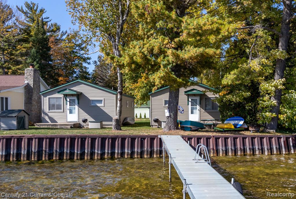 Welcome to your serene lakefront retreat! This unique property features three private, fully redecorated cottages, offering comfort and privacy for families, friends, or guests. Inside, each cottage boasts fresh paint, a mix of newer vinyl and carpet, upgraded electrical, cozy bedrooms, and fully appointed kitchens, making entertaining or extended stays a breeze. A spacious dock invites you to take in breathtaking sunrise views over the clear, sandy bottom lake, perfect for swimming, boating, and all day enjoyment. The property also includes a variety of outdoor water toys, adding to the fun for all ages. Evenings are best spent gathered around the two firepits, sharing stories beneath starry skies. With peaceful surroundings, endless outdoor activities, and stunning scenery, this property has been a successful Airbnb rental but is equally ideal as a private getaway. All appliances are included, along with furnishings. Roof on cabin #1 was replaced in July 2025. Agent owned.