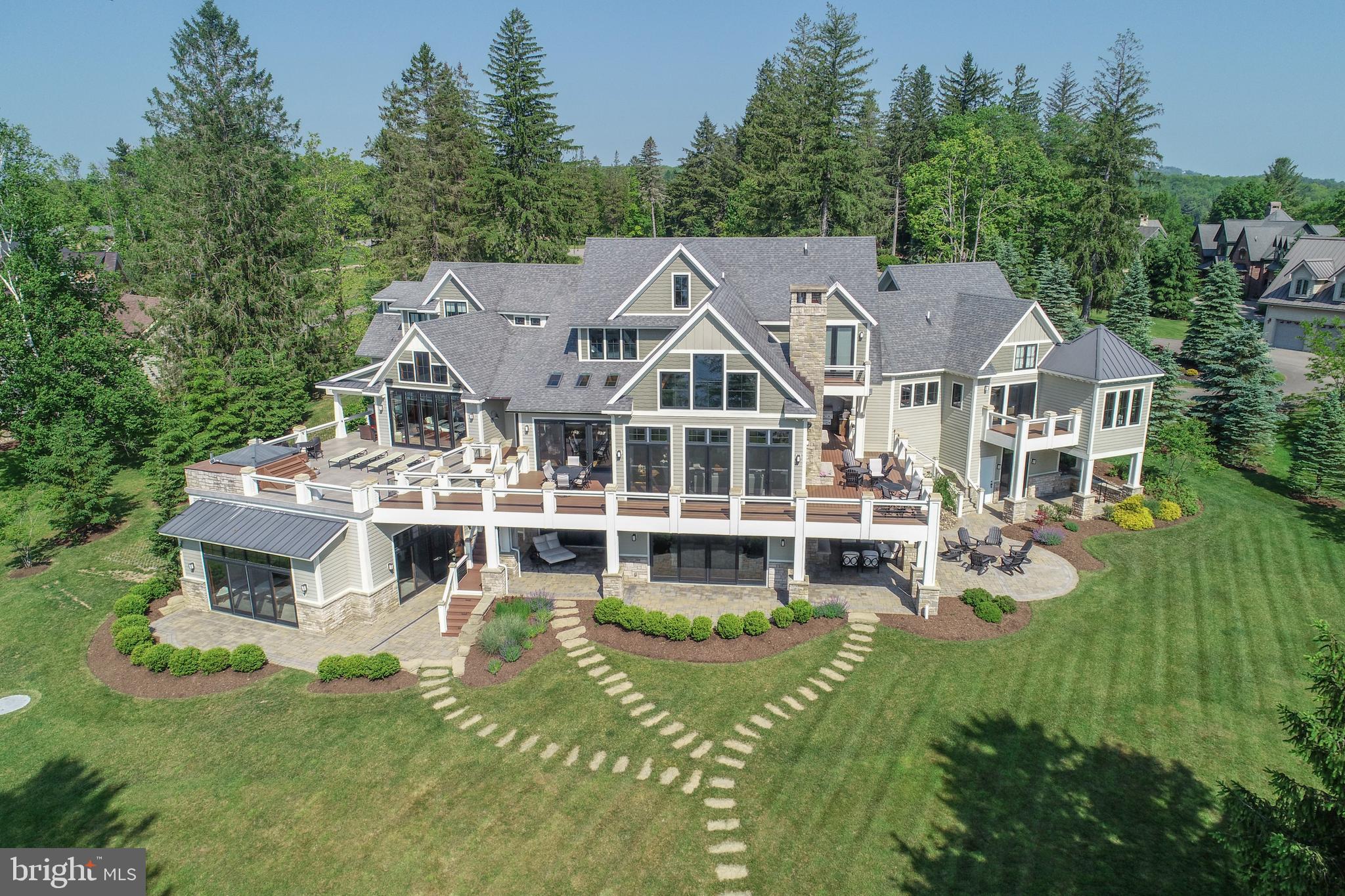 Luxury lakefront living at its peak. This 11,417 sq ft masterpiece sits on 1.65 acres in The Reserve at Holy Cross with 345 feet of Deep Creek Lake frontage and an engineered DNR-approved sea wall. Crafted in 2016, the home features timber-framed vaulted ceilings, wide-plank hardwood floors, and panoramic lake views from nearly every room. The commercial-grade kitchen anchors the main level with a sprawling island, Wolf range, and access to a four-season room that opens fully to the outdoors through custom bi-fold doors. The main-level primary suite spans nearly 900 sq ft with a private balcony, soaking tub, his-and-her vanities, and a massive walk-in closet. Enjoy five fireplaces, an indoor pool with fountains and a full bath, and three levels of outdoor living, including an outdoor kitchen, built-in hot tub with gazebo, outdoor shower, and deck drainage system to keep lower levels dry. Entertain with ease in the rec room with an industrial-style bar, climate-controlled wine cellar, and fully equipped gym. Three attached garages connect to a locker-style mudroom, with a lower-level garage ideal for a side-by-side or lake toys. Radiant heat, a whole-house generator, and three dock slips make this property as functional as it is flawless. A rare opportunity to own a true statement home in one of Deep Creek Lake’s most prestigious communities. Call today for your private tour!
