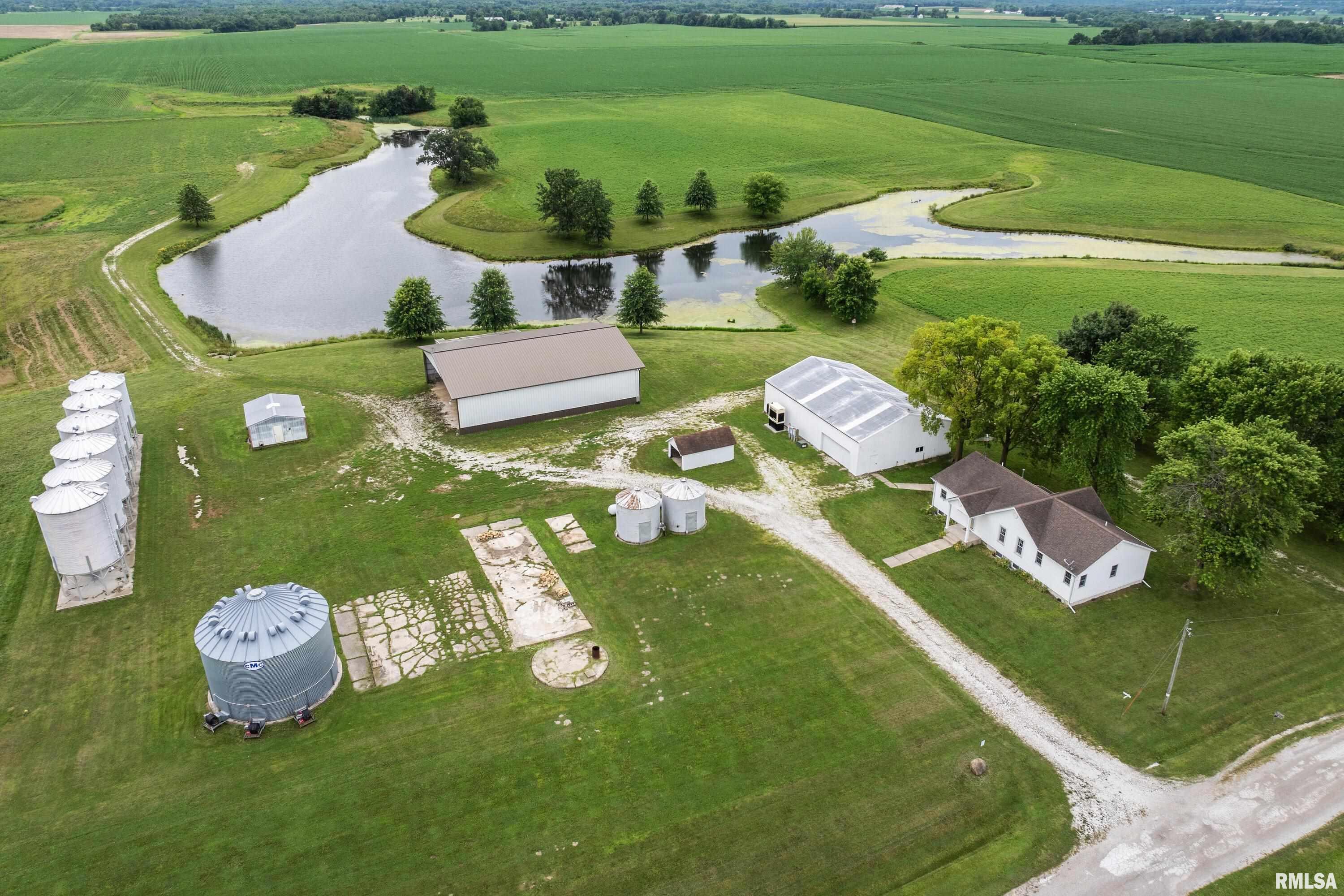 Welcome to the perfect farm setting you’ve been searching for. This remarkable 39.5-acre property offers peaceful country living with everything you need to enjoy life on the land. From rolling tillable fields to a fully stocked private lake, this is an opportunity to own a true rural retreat. The 3-bedroom, 3-bathroom home features beautiful hardwood floors, tall ceilings, and an open-concept layout with main-floor laundry. A spacious master suite addition creates a comfortable haven to unwind, while the partially finished basement with a poured foundation provides excellent extra space and potential. Outdoors, the property is exceptionally well-appointed for farm and hobby use, with multiple outbuildings including a 64x42 shop, a 60x75 machine shed, and multiple silos. A unique greenhouse has been used for organic gardening, offering endless possibilities. Approximately 23 acres of tillable land are ready for planting or rental income, while the 5-acre stocked lake invites you to fish for bass, catfish, and bluegill right at home. Additional amenities include a powerful diesel generator that can run both the home and the shop, two owned LP tanks (one for the house, one for the shop). This is a rare opportunity to enjoy the tranquility, space, and versatility of a true country farm setting—all in a great location!