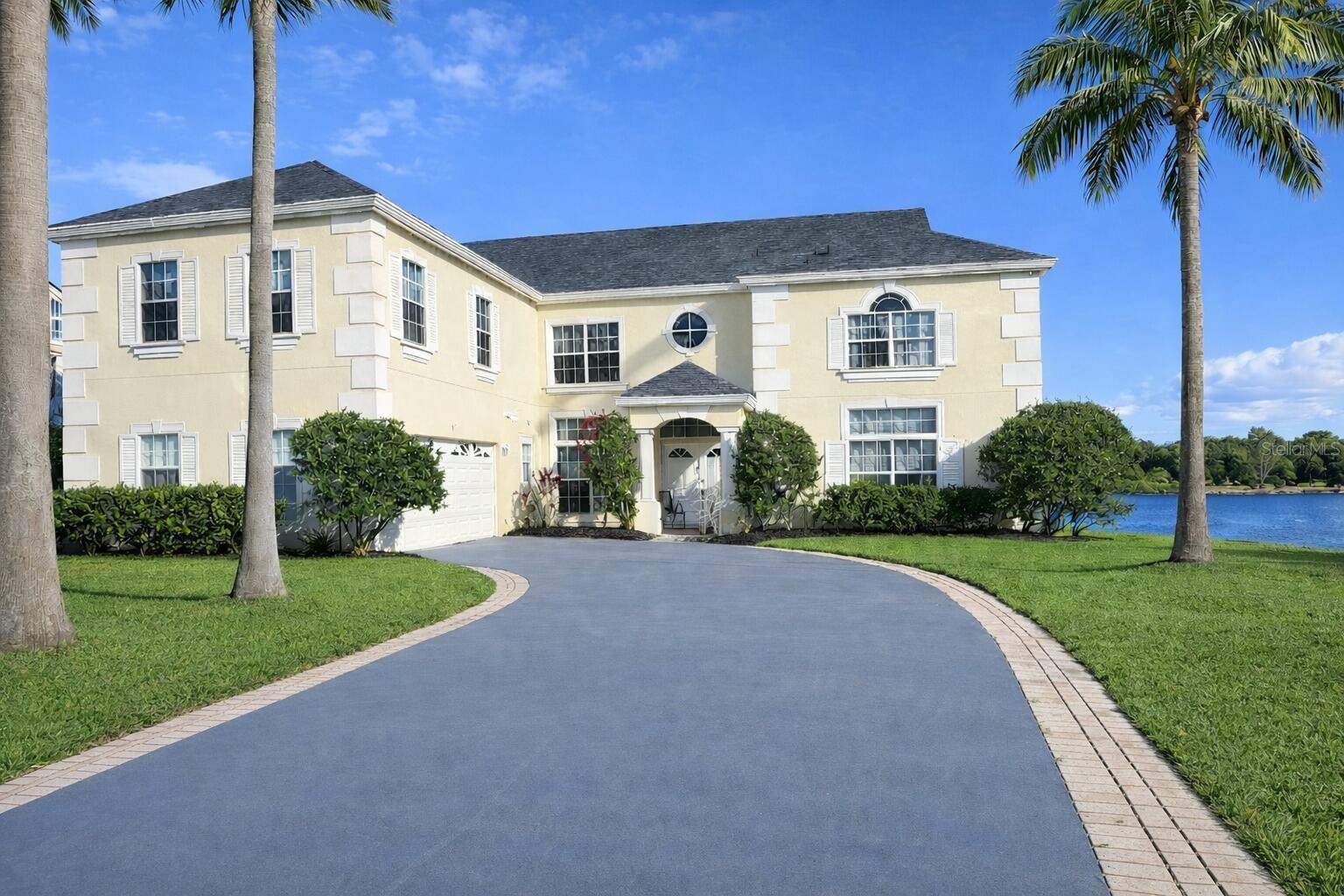 One or more photo(s) has been virtually staged. WELCOME TO PARADISE — RARE LAKEFRONT ESTATE ON OVER ½ ACREWelcome home to this lakefront estate set on a quiet dead-end cul-de-sac, just under 4,000 square feet of living space on an over half-acre lot. Expansive lake and pool views, mature palm trees and daily sightings of ducks, cranes, pelicans and Florida’s exotic birdlife create a peaceful, private, tranquil setting hard to fine.A dramatic 2-story foyer welcomes you with soaring 10-foot ceilings on both levels and abundant natural light. The layout is open, thoughtfully designed, and features generous room sizes with no wasted space.The home includes 4 bedrooms and 3 full bathrooms, including a cabana bath with direct pool access. Bedrooms feature large walk-in closets, with 1 having a built-in. The oversized primary suite enjoys tranquil lake views and features a new primary bathroom with upscale designer spa-style finishes, a soaking tub, and large glass-enclosed shower.The kitchen captures sweeping lake and water views and opens seamlessly to the main living areas. The family room is anchored by a real wood-burning fireplace, recently redesigned with designer tile coordinated with the kitchen backsplash.There are two additional rooms on the first floor that may be used as offices, gyms, media rooms, guest rooms or whatever your heart desires. Upstairs includes a spacious loft and a massive room above the garage for exceptional versatility and a wide array of uses.Architectural details are found throughout the home including coffered ceilings, crown molding, built-in shelving, niches, and cut-outs that give the property a finished, custom feel.Outdoor living features a screened-in pool positioned to take full advantage of the lake views. A lake-clearing project completed a year ago restored wide, open water views enjoyed today.Major Improvements Include:• New roof (late 2023)• Complete re-pipe plumbing (late 2023)• New AC downstairs (late 2023)• New primary bathroom• New water heater• New pool pump and filter• All new lighting throughout• Fresh interior and exterior paint, including garage• And many additional improvementsConveniently located near Disney, dining, shopping, entertainment, world class theme parks & an international airport while still maintaining the serenity of true lakefront living. Some photos have been virtually rendered.