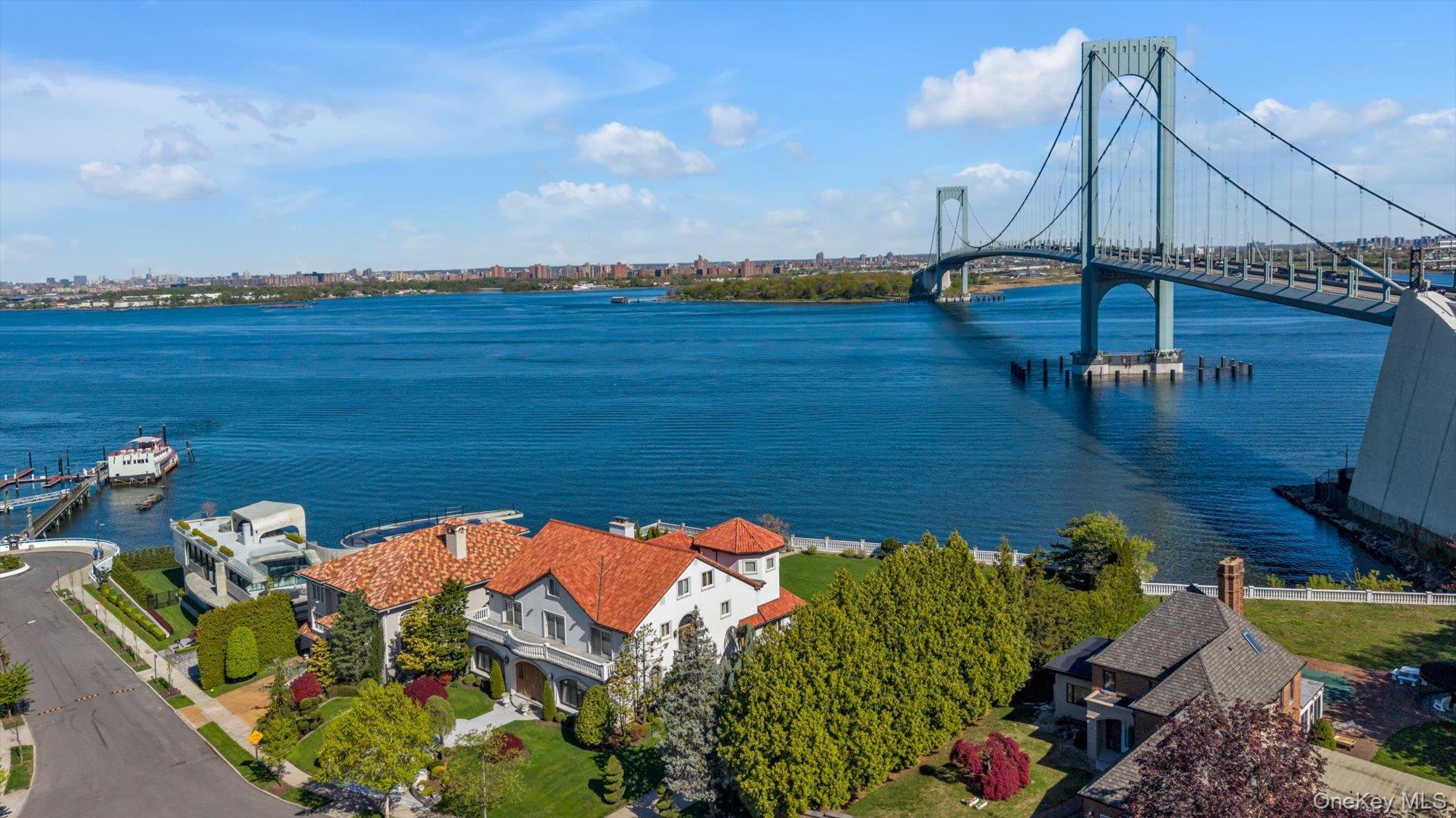 Set on a half-acre with 128 feet of direct waterfront, this 6,500 sq ft residence offers panoramic water views and a solid structural foundation. Rebuilt in 1980 with concrete and block construction, the home features detailed millwork, Kentucky oak, and Carrara marble flooring—preserve its distinctive elements while making the rest your own private oasis. Nearly every room captures waterfront and bridge views,  where the water creates a sense of calm and fills the home with natural light.The main level features a gracious entry foyer with coat closet, Large EIK with center island, a formal dining room with custom built-ins and sliding doors to a waterfront patio, a formal living room with fireplace, a den, a sunken sitting room, a private office/bedroom, and powder room. The second level offers four spacious en-suite bedrooms, an additional full bathroom, and an impressive bonus room with soaring 25-foot ceilings. The third floor provides separate living quarters with private exterior access, and features two bedrooms, a full bathroom, a large living/game room, and multiple storage rooms—ideal for extended family or guests.The basement includes both a sauna and a steam room for a private, spa-like experience.A long and wide driveway leads to a six-car garage. Additional highlights include CAC, central vacuum, a large balcony, Romeo and Juliet balconies, Closets galore all cedar-lined, Sliding doors to back yard patio, remarkably low taxes and more.For boating enthusiasts, nearby dockage is available.