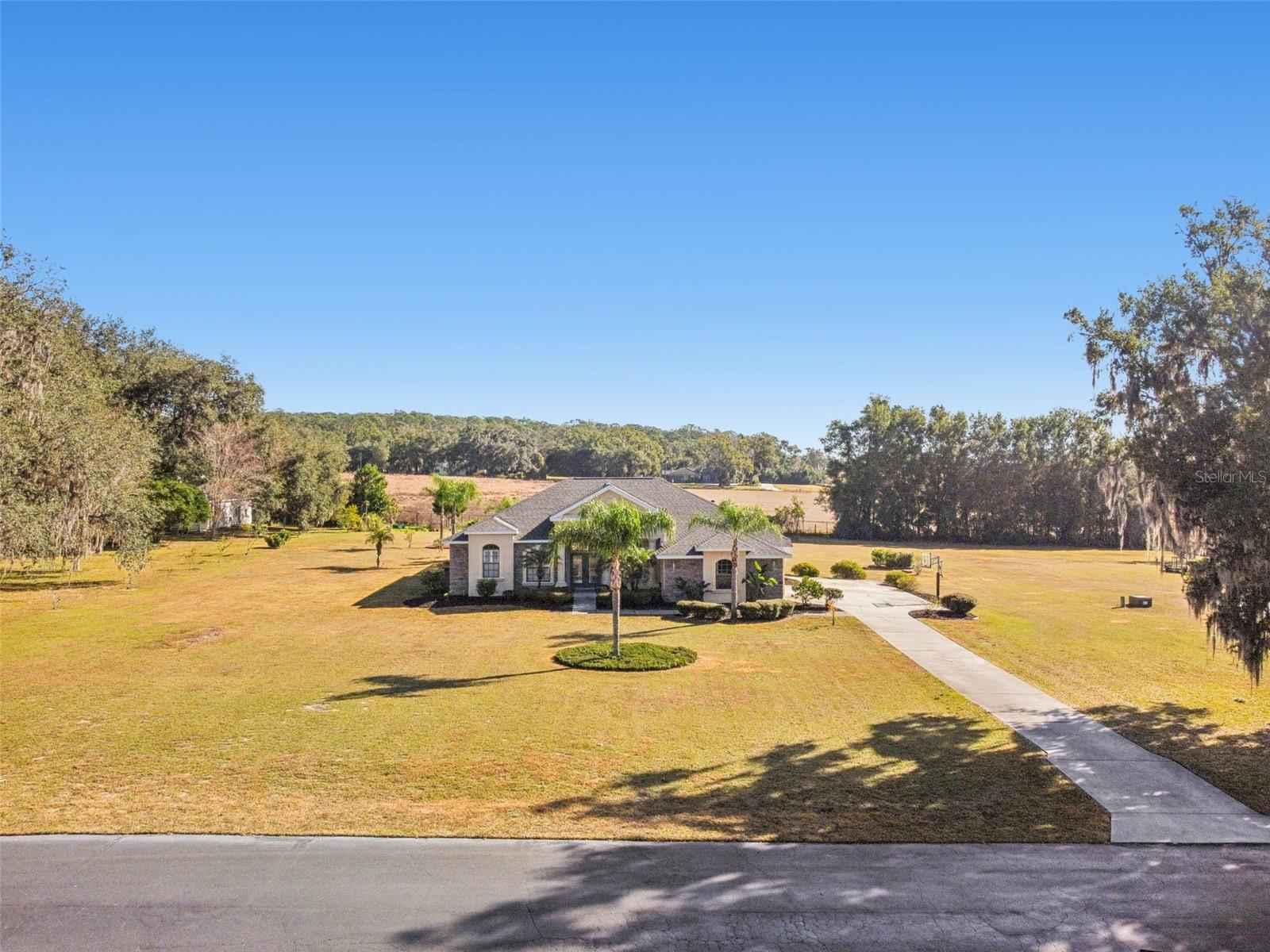 Custom-Built, Single-Story Multigenerational Pool Home on 1.55 Acres in Gated Willow Run (No CDD)Welcome to this exceptional one-story multigenerational residence situated on a sprawling 1.55-acre homesite within the exclusive, gated community of Willow Run. This intimate enclave features fewer than 12 homes and is ideally located on St. Joe Road in Dade City, offering privacy, convenience, and a true sense of community.Boasting over $100,000 in recent upgrades, this thoughtfully designed home offers 5 bedrooms, 3 bathrooms, a sparkling pool with heated spa, and a rare mother-in-law suite complete with existing kitchen and laundry hookups—perfect for extended family or flexible living arrangements.Recent upgrades include a dimensional shingle roof (2024), pool resurfacing (2021), new A/C condenser and air handler (2023), new septic drain field (2021), epoxy-coated garage flooring (2026), luxury vinyl plank flooring throughout (2026), fresh interior and exterior paint (2026), gazebo (2021), hot water heater (2024), and updated hardware and sink in the guest bath (2025).This self-sufficient property uniquely combines the security and convenience of city living with the freedom, privacy, and space of a country estate. The side-entry, three-car garage is complemented by an extra-long 150+ foot driveway and additional parking pad—ideal for guests, recreational vehicles, or multigenerational households.Architectural highlights include double glass front doors, wood shutters, soaring ceilings, crown molding, and abundant natural light. The home’s ideal east-facing orientation provides serene views of your private garden oasis and gazebo.The well-designed split floor plan places the primary suite on the west side of the home, offering maximum privacy, while the additional bedrooms and mother-in-law suite are located in the east and north wings.Conveniently located near hospitals, shopping, dining, and historic Downtown Dade City, residents enjoy small-town charm with boutique shopping and dining, while remaining within easy reach of Tampa International Airport, Disney, and Florida’s beautiful beaches.This is a rare opportunity to own a meticulously maintained, multigenerational estate in one of Dade City’s most desirable gated communities. 3D Tour: https://my.matterport.com/show/?m=PXwNTEGLS7x&brand=0&mls=1&