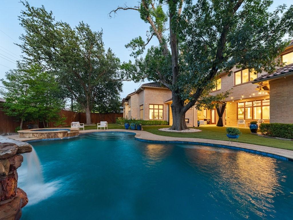 Nestled in the coveted heart of Preston Hollow, 6507 Lupton Drive is a 6,300-square-foot Spanish-style masterpiece that seamlessly blends timeless architecture with a sophisticated, resort-like lifestyle.Behind its freshly painted façade and impeccable landscaping, you’ll find five spacious bedrooms and five-and-a-half baths, a private study, and an open-concept kitchen designed for culinary artistry and effortless entertaining. Sun-filled living and dining areas feature graceful archways and rich finishes that celebrate the warmth of Spanish design.Step outside to a luxurious backyard retreat where a covered outdoor living area with a stone fireplace invites year-round gatherings. The sparkling pool, complete with water feature, and expansive patios create the perfect setting for outdoor entertaining.