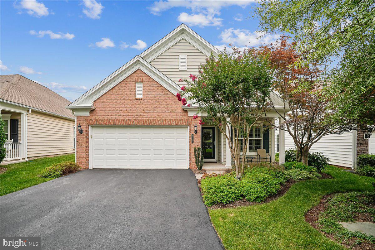 EXCEPTIONAL MAIN-LEVEL LIVING AWAITS IN THE HIGHLY SOUGHT-AFTER 55+ POTOMAC GREEN COMMUNITY BY DEL WEBB. THOUGHTFULLY DESIGNED FOR BOTH COMFORT AND ELEGANCE, THIS BEAUTIFULLY APPOINTED HOME OFFERS AN OPEN FLOOR PLAN, QUALITY FINISHES, AND THE EASY LIFESTYLE YOU HAVE BEEN WAITING FOR.  STEP INSIDE THE FOYER, WHERE CHAIR RAILING, SHADOW BOX MOLDING, AND LVP FLOORING SET THE STAGE FOR THE BEAUTIFULLY DESIGNED INTERIOR. THE LVP FLOORING FLOWS SEAMLESSLY THROUGHOUT THE MAIN LIVING AREAS, CREATING A WARM AND COHESIVE FEEL. JUST OFF THE FOYER, A GLASS PANELED DOOR OPENS TO A PRIVATE DEN FEATURING RECESSED LIGHTING AND PLANTATION SHUTTERS, PROVIDING THE PERFECT SPACE FOR A HOME OFFICE, LIBRARY, OR QUIET RETREAT WHILE ENJOYING VIEWS OF THE GREEN SPACE BEYOND.  CONTINUE INTO THE EXPANSIVE FORMAL LIVING AND DINING ROOMS, WHERE CUSTOM MOLDINGS AND A DECORATIVE CHANDELIER MEDALLION CREATE AN ELEGANT SETTING FOR HOLIDAY GATHERINGS, DINNER PARTIES, OR EVERYDAY ENTERTAINING.  THE GOURMET EAT-IN KITCHEN IS SURE TO IMPRESS THE HOME CHEF. FEATURING TILE FLOORS, GRANITE COUNTERTOPS, A CUSTOM TILE BACKSPLASH, ABUNDANT CABINETRY WITH UNDER-CABINET LIGHTING, DOUBLE OVENS, A COOKTOP, A PANTRY, A BREAKFAST BAR, AND A SEPARATE DINING AREA, THIS SPACE COMBINES BEAUTY AND FUNCTION FOR EVERYDAY LIVING.  OPEN TO THE KITCHEN, THE FAMILY ROOM OFFERS A COMFORTABLE PLACE TO GATHER OR SIMPLY RELAX AT THE END OF THE DAY. WHEN THE WEATHER IS NICE, STEP OUTSIDE TO THE CUSTOM FLAGSTONE PATIO WITH AN ELECTRIC AWNING, WHERE YOU CAN ENJOY MORNING COFFEE, DINE AL FRESCO, OR UNWIND WHILE OVERLOOKING THE MATURE TREES AND BEAUTIFULLY FENCED REAR YARD.  THE SPACIOUS PRIMARY SUITE FEATURES NEUTRAL CARPETING, A LARGE WALK-IN CLOSET, AND A PRIVATE EN SUITE BATH APPOINTED WITH TILE FLOORS, A DUAL SINK VANITY WITH GRANITE COUNTERTOPS, AMPLE CABINETRY, AND A STAND-ALONE SHOWER.  THE SECOND BEDROOM ALSO FEATURES NEUTRAL CARPETING AND ENJOYS PRIVATE ACCESS TO THE SECOND FULL BATH, WHICH IS ALSO ACCESSIBLE FROM THE HALLWAY AND FEATURES TILE FLOORS AND A TUB/SHOWER COMBINATION.  ADDING TO THE HOME'S CONVENIENCE IS A MAIN-LEVEL LAUNDRY ROOM COMPLETE WITH A SIDE-BY-SIDE WASHER AND DRYER, UTILITY SINK, CABINETRY, AND DIRECT ACCESS TO THE TWO-CAR GARAGE.  ENJOY THE RESORT-STYLE AMENITIES THAT HAVE MADE POTOMAC GREEN ONE OF THE AREA'S MOST DESIRABLE ACTIVE ADULT COMMUNITIES, ALL WHILE BEING JUST MINUTES FROM SHOPPING, RESTAURANTS, MAJOR COMMUTER ROUTES, AND EVERYTHING YOU NEED FOR CONVENIENT EVERYDAY LIVING. SOME UPDATES/IMPROVEMENTS INCLUDE: FURNACE HUMIDIFIER (2025),  HOT WATER HEATER (2023), LVP FLOORING (2023)