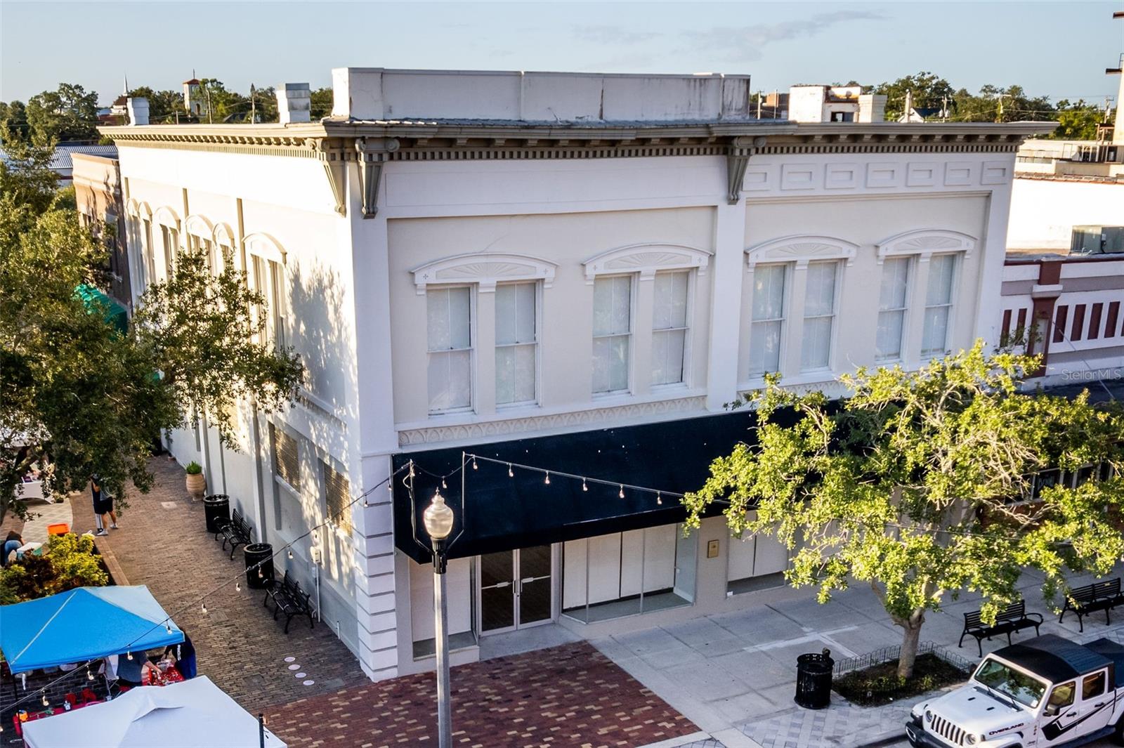 Don’t miss this rare opportunity to own a remodeled historic commercial building in the most desirable location in Downtown Sanford’s vibrant First Street business district. Perfectly positioned between 1st Street and Magnolia to be among the city’s bustling shops, restaurants, and entertainment venues, this property offers unmatched visibility and endless potential for investors or owner-users alike.
Meticulously updated from top to bottom, the building combines modern functionality with timeless character and craftsmanship.
The first floor features an expansive open-concept layout ideal for mixed-use applications such as retail, restaurant, office, or event space. With its original exposed brick walls, soaring open-air ceilings, three bathrooms, and a convenient kitchenette, this level provides an inviting, flexible space ready to adapt to any business vision.
The second floor, with its impressive two-story ceilings, offers a thoughtfully designed professional setting featuring eight private offices, a break room, and a restroom. Front-facing windows have been soundproofed, maintaining a peaceful work environment even when downtown is lively below.
Recent upgrades include fresh interior paint, new LVP flooring on the first floor, new carpet on the second floor, a new A/C system installed in 2023. Every detail has been attended to, ensuring this historic property is as functional as it is beautiful.
Blending classic architectural charm with contemporary updates, this building is  an ideal investment opportunity as it is located in Central Florida’s most walkable and rapidly growing downtown corridors.