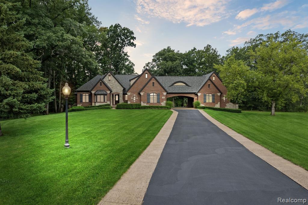Welcome to this exceptional custom-built ranch, located in the prestigious, gated community of Woodland Waters in Bruce Township. Privately set at the end of a cul-de-sac on a beautifully wooded 2-acre parcel, this one-of-a-kind property offers refined elegance, thoughtful design, and unmatched functionality. Meticulously maintained and in model-like condition, this 4-bedroom, 3 full and 2 half bathroom residence features finely crafted living spaces, enhanced with high-end materials and quality finishes throughout. The gourmet island kitchen is a standout, offering premium stainless steel appliances, ample cabinetry, and generous countertop space—perfectly designed for both everyday living and entertaining. The adjoining great room is enhanced by soaring ceilings, custom architectural beams, and expansive windows that invite in abundant natural light, creating a warm and inviting atmosphere. Wide-plank hardwood flooring flows throughout the entire main level, enhancing the home’s cohesive and elegant aesthetic. The spacious primary suite includes a luxurious en-suite bathroom, a large walk-in closet, and direct access to a versatile flex room that may serve as a library, home office, or private sitting area. The fully finished daylight basement expands the living space with a secondary kitchen, a half bath, and a wide-open area ideal for recreation, gatherings, or future customization. Above garages, an additional room offers a spacious fourth bedroom with a full bathroom and a flexible open space suitable for entertainment, hobbies, or guest accommodations. Car enthusiasts and those in need of storage will appreciate the attached garage parking for up to six vehicles. The home also features a geothermal heating and cooling system, providing energy efficiency and long-term sustainability. Schedule your private showing today and experience the outstanding quality this residence provides.