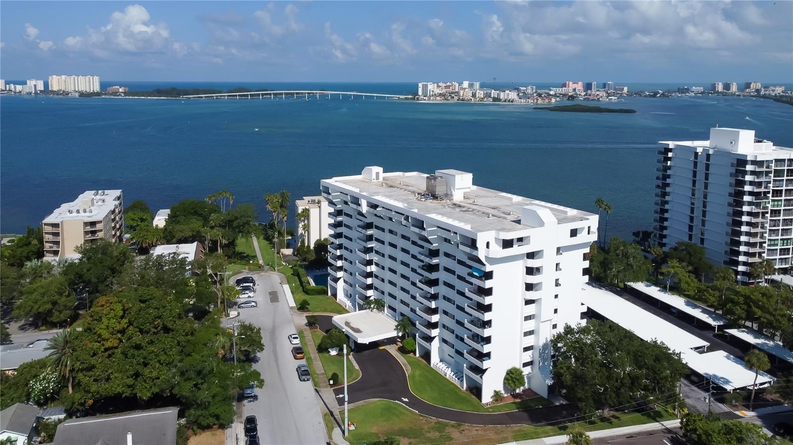 The best of two worlds converge into a perfect and vibrant 55 plus lifestyle right here at 30 Turner St. Built to stand the test of time, this block and steel constructed fortress caters to the beach life but was built on high ground and architecturally designed to redirect wind while maximizing the incredible views of Clearwater Beach and the Intracoastal Waterway. This sprawling 2nd floor northwest facing unit has been meticulously updated just one year ago and is adorned with a brand new open concept kitchen and luxury vinyl plank flooring throughout. Floor to ceiling sliders guide you out to your expansive balcony with breathtaking views of Clearwater Harbor and the Clearwater Memorial Causeway. The dining and living room flow effortlessly and are accompanied by high ceilings, fresh interior paint, and high end lighting. The Primary bedroom is awe inspiring with serene water views, spacious walk-in closet, and en-suite bathroom. Down the hall from the Primary is a modern half bath for guests. Multiple closets, cabinetry and a large first floor dedicated locker for gear offer additional storage. A dedicated covered carport and ample guest parking are sure to please.  Elevators and a convenient washer and dryer room are just down the hall from the unit.  The main level of the building offers resort style amenities with fitness center, heated pool, library, billiards room, banquet room, and  restrooms. The affordable HOA payment includes water, sewer, trash, pool, maintenance, security, insurance on the building, basic cable, internet, exterior landscaping, and pest control.  The heated swimming pool and loungers offer both relaxation and rejuvenation. A community park is just outside and is the ideal place to take your pets, get your steps in, or soak in the natural vitamin D.  The park also has a large fishing pier and fish cleaning station situated right on the Intracoastal.  Head down to watch jaw dropping sunsets and watch the pirate ship and dolphin tour boats pass by.  This complex is pet friendly allowing up to two pets at or under 20lbs each.  The location is a can't miss as you are surrounded by wonderful shopping plazas, public transit, local seafood, and is just across the bridge from world famous Clearwater Beach with its stunning turquoise waters and powder sand beaches.  This is a unit and opportunity that truly sells itself and seeks a new owner to fill it with continued love and new memories.  Flip flops and sunscreen required!