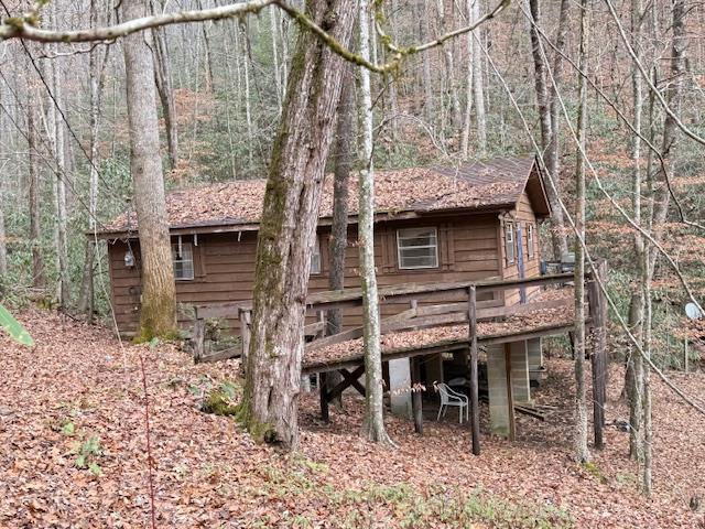 2 bedroom 1 bath creekfront cabin nestled in the mountains of Western North Carolina. Situated on 1.20 acres of private, wooded, unrestricted land surrounded by mountains and peaceful forest. Enjoy the sounds of a gentle creek from the firepit or relax on the screened porch overlooking the creek. Secluded and serene, yet full of potential. This property would make an ideal mountain getaway or vacation rental.  Private well. Being sold AS-IS.