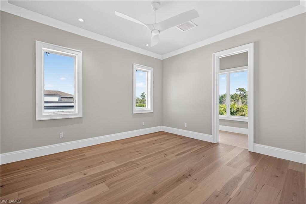 Unfurnished room featuring light wood finished floors, a ceiling fan, and ornamental molding