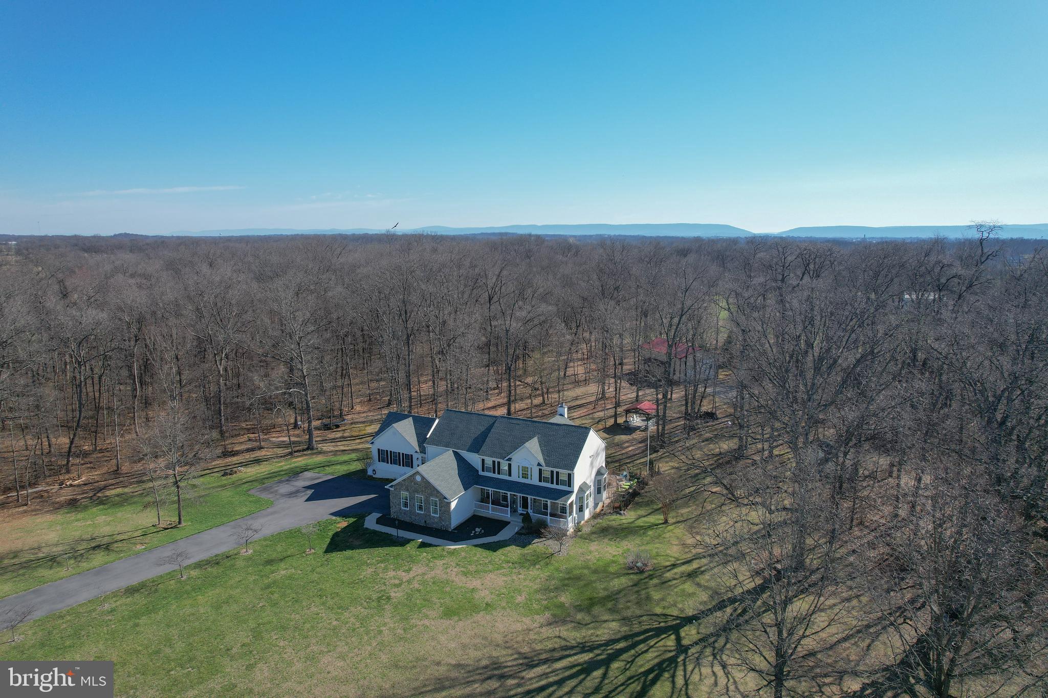 Set on 3.55 acres in the prestigious Preserve at Barleywood, this exceptional estate offers nearly 5,000 finished square feet designed for today’s modern living needs—where luxury, flexibility, and functionality come together seamlessly just minutes from Charles Town and within reach of Northern Virginia commuter routes.This 5-bedroom, 6.5-bath residence is thoughtfully designed for multi-generational living, featuring a fully integrated in-law suite that lives like a private residence of its own. The suite includes a full bedroom, accessible bath with walk-in shower, widened doorways, seamless low-maintenance LVP flooring, a full KitchenAid appliance package, efficiency kitchen, private laundry, and dedicated living and dining space—ideal for extended family, guests, or long-term flexibility.Beyond the suite, the main home unfolds with a classic, welcoming design and over 4,000 square feet of expansive living space. A bright, open foyer sets the tone, leading into a dramatic two-story living room with soaring windows and a wood-burning fireplace. The kitchen is both functional and beautiful, featuring a gas range, granite countertops, center island, rich wood cabinetry, and an extended sunroom dining area that captures sweeping views of the surrounding landscape.Additional main-level spaces include a formal dining room and a flexible sitting room or office, all anchored by hardwood flooring throughout. The upper level offers generously sized bedrooms, including a spacious primary suite designed for comfort and retreat.The home also includes a massive unfinished basement, offering incredible potential for future expansion—whether envisioning a home theater, fitness space, additional living quarters, or recreation area.Step outside and the property truly becomes something special. The outdoor living experience is designed for both relaxation and entertaining at scale. A 20x40 in-ground pool is surrounded by extensive hardscaping, complemented by a two-tier composite deck overlooking the space. The pool house is fully equipped with bar seating, lounge area, and a full bathroom, creating the perfect setting for gatherings that carry from day into evening.The grounds offer multiple areas to dine, entertain, and unwind, including a covered fire pit area ideal for quiet nights and storytelling. Practicality meets lifestyle with abundant storage, including space beneath the deck, a 10x12 shed for tools and pool equipment, and an impressive 30x50 pole barn with RV-height door—perfect for hobbyists, business use, or recreational storage.A double driveway with lighting extends to the rear of the property, complete with RV electrical hookup and additional parking near the pole barn, offering flexibility rarely found in residential settings.Significant system upgrades provide peace of mind, including three HVAC systems (recently replaced), a new mini-split in the pool house, updated septic field, new well pump (2020), whole-house water treatment system with reverse osmosis, UV light, and filtration, a 1,000-gallon propane tank, and a new roof with 50-year architectural shingles.This is more than a home—it’s a private retreat, an entertainer’s dream, and a solution for evolving living needs, all within one of Jefferson County’s most sought-after communities.For buyers searching for space, versatility, and a property that truly delivers on both lifestyle and location, 140 Parliament Way stands in a category of its own.