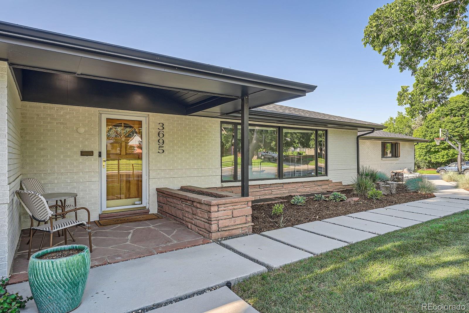 Welcome to this exquisite Southern Hills ranch! Set on a uniquely configured lot fully enclosed by a sleek, contemporary steel fence, the entire yard flows seamlessly from front to back, making every inch usable. Want privacy? The shaded back patio (with retractable shades), hot tub, and lush grassy area offer just that. Beautifully landscaped with a perennial and vegetable garden surrounding a tranquil water feature, the outdoor space is nearly as impressive as what’s inside.Step through the front door into a welcoming foyer that leads to a sun-filled living room, anchored by a wood-burning fireplace. The open layout flows effortlessly to the dining area and the chef’s kitchen—complete with custom cabinetry, quartz countertops, newer stainless appliances, and a spacious center island that doubles as a breakfast bar.Need more room to relax? A cozy den with another wood-burning fireplace and a sunroom with heated floors provide the perfect spots for movie nights, game days, or quiet morning coffee.The primary suite is a true retreat, featuring a luxurious spa-like bathroom with soaking tub, walk-in shower, dual vanities, and a custom walk-in closet. Two additional bedrooms share a cleverly designed Jack-and-Jill bath with private vanities and separate shower and toilet rooms—ideal for busy households.The fully finished basement, accessible by two staircases (one off the foyer and one through the pantry), offers even more living space. A large guest bedroom with updated bath, a generous entertainment zone with another fireplace, and a tiled game room make this the ultimate hangout level.Walk to Wellshire Golf Course, Eisenhower Rec Center, and top-rated Slavens K–8. Enjoy proximity to local restaurants, shops, and conveniences—all from a home that blends relaxed elegance with thoughtful upgrades.