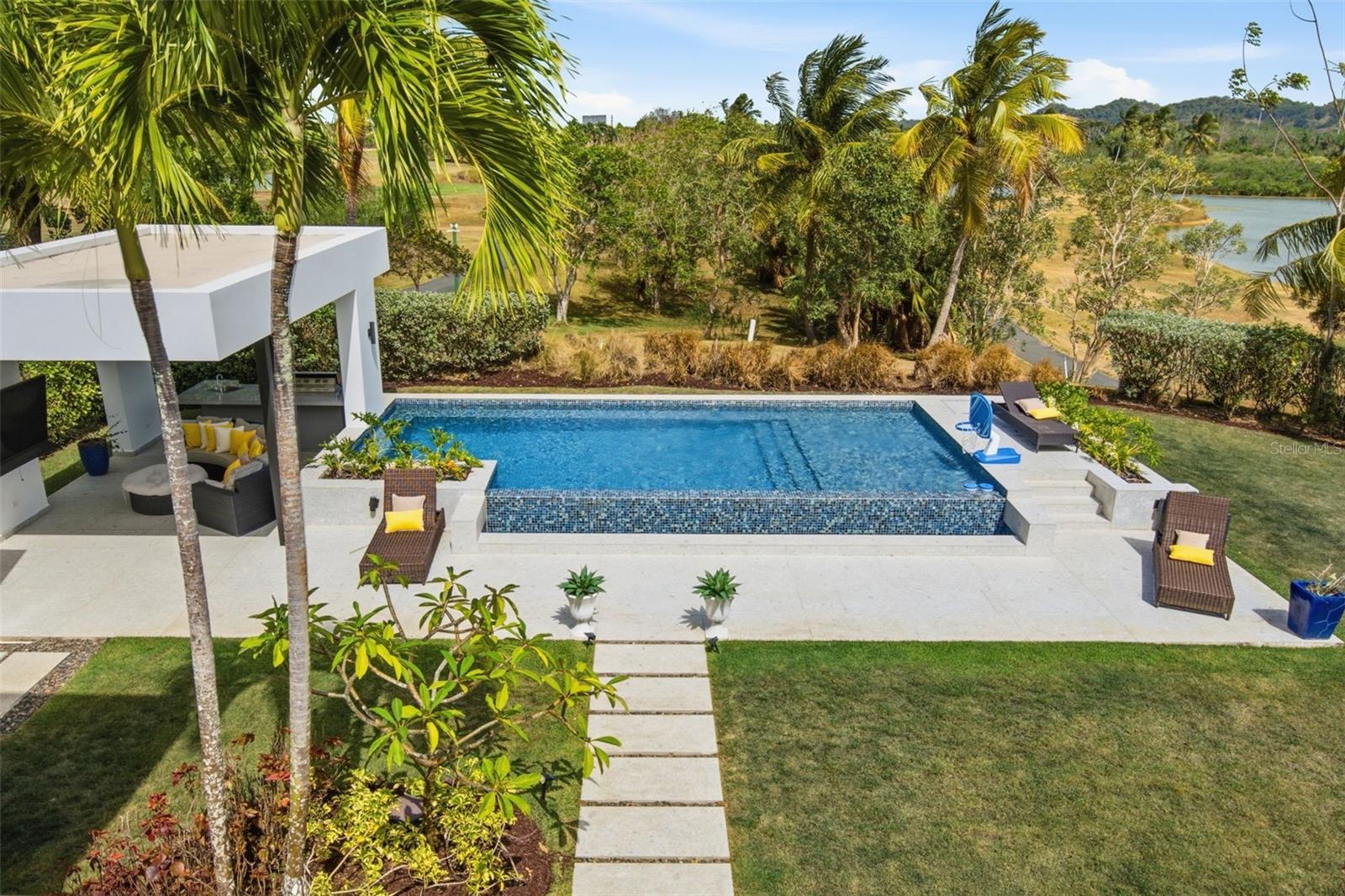 Welcome to Cay Pointe, The Enclave.Newer construction meets old-soul island charm. Striking modern architecture on the outside; warm, natural textures and rich wood tones on the inside. The kind of space that doesn't just look like a vacation..it is one. Perched along the golf course with gorgeous lake views, Cay Pointe gives you what almost nothing else in the Enclave can: water views, golf course views, and real privacy all at once. Views without golf carts blocking your view and privacy thanks to landscaping that wraps the property in palm fronds and greenery. You get the view. Not the audience. Inside, the design carries that same easy, breezy vibe, woven textures, natural fiber accents, and a palette pulled straight from sand and sea. A property that feels modern, yet relaxed. Generous living spaces and thoughtfully curated interiors create a retreat that's as ready for a quiet Tuesday as it is for a party. And for the days the world doesn't stop, a dedicated, separate office gives you a real room to close the door and get to work, fully removed from the living areas, so home never has to feel like the office.Newer construction. A rare lot. Views you can't manufacture, no matter how good your landscaper is. All in the heart of Dorado Beach.