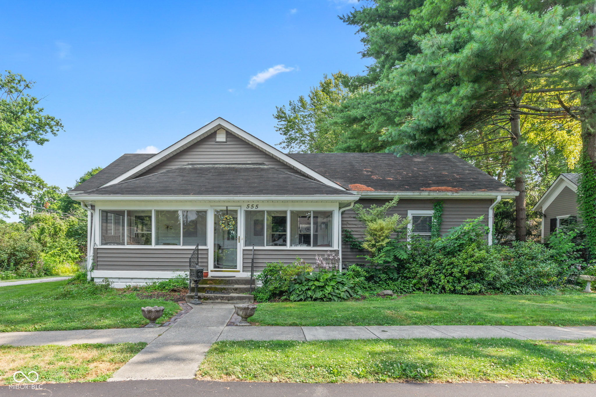 Welcome to this charming home, built in 1923 and nestled in the heart of Zionsville's Village. Situated on a double lot boasting 0.26 acres, 555 Hawthorne offers prime real estate with unbeatable walkability to the iconic brick street. Enjoy easy access to downtown restaurants, shops, parks, trails, and year-round community events.    This property presents a wonderful opportunity as is, or you can expand and create your dream home. The updated kitchen features granite countertops and seamlessly opens to an addition that includes a second sitting room, a slider to the outside, and a master suite. A finished staircase leads to a finished landing that opens to a full, unfinished attic space, ready to be customized with a variety of options. The basement is accessible from the kitchen, and there's a convenient back door leading outside.    Enjoy your morning coffee on the carpeted, enclosed front porch, or host gatherings on the large composite back deck overlooking the fully fenced backyard. The property also includes a detached two-car garage with alley access. Whether you're looking to move right in or explore the endless possibilities for renovation or expansion, this home is a rare find in Zionsville.