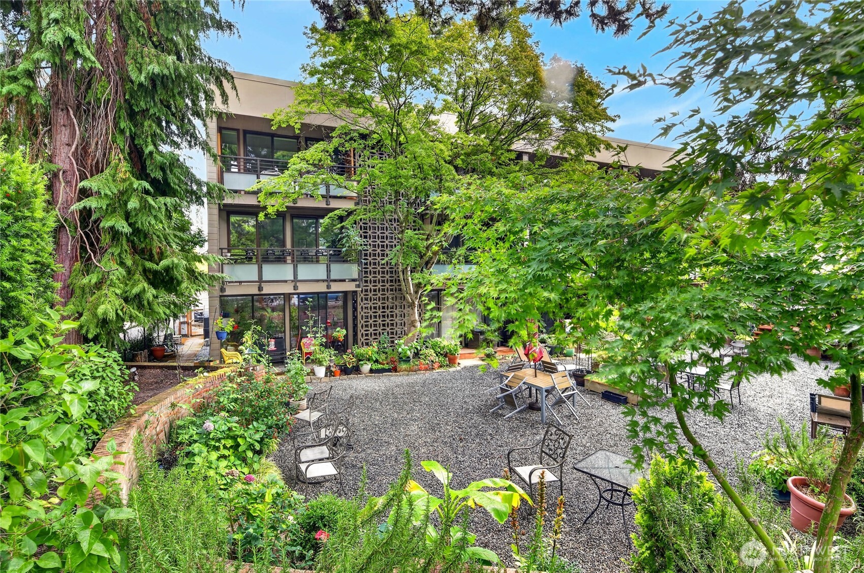 Nestled on a quiet street with serene tree cover, this mid century modern top floor 1 bedroom condo provides zen light and energy while being just a hop, skip, and jump from the bustle and amenities of coveted Madison Park. Entry foyer greets with ample storage on both sides of the hallway. Enter into the generously sized dining and living room with floor to ceiling windows, gorgeous brand new engineered hardwood floors, automated window covers, and perfect treehouse feeling private deck. Kitchen with cherry cabinets and efficient design, but if cooking is not your jam, then there are a dozen eateries within close proximity. Spa-like bathroom with bidet and glass enclosed shower. Big bedroom offers plenty of space for WFH and / or a king size bed + dual closets. Park Lane is a welcoming retro 1950s community of 15 homes. Laundry rooms and storage on each level. Contemplating a car free lifestyle? This is the ultimate opportunity to ground into a community with everything at your finger tips: shops, restaurants, groceries, coffee, and public transportation. An idyllic existence in the midst of the city IS possible. It's right here.