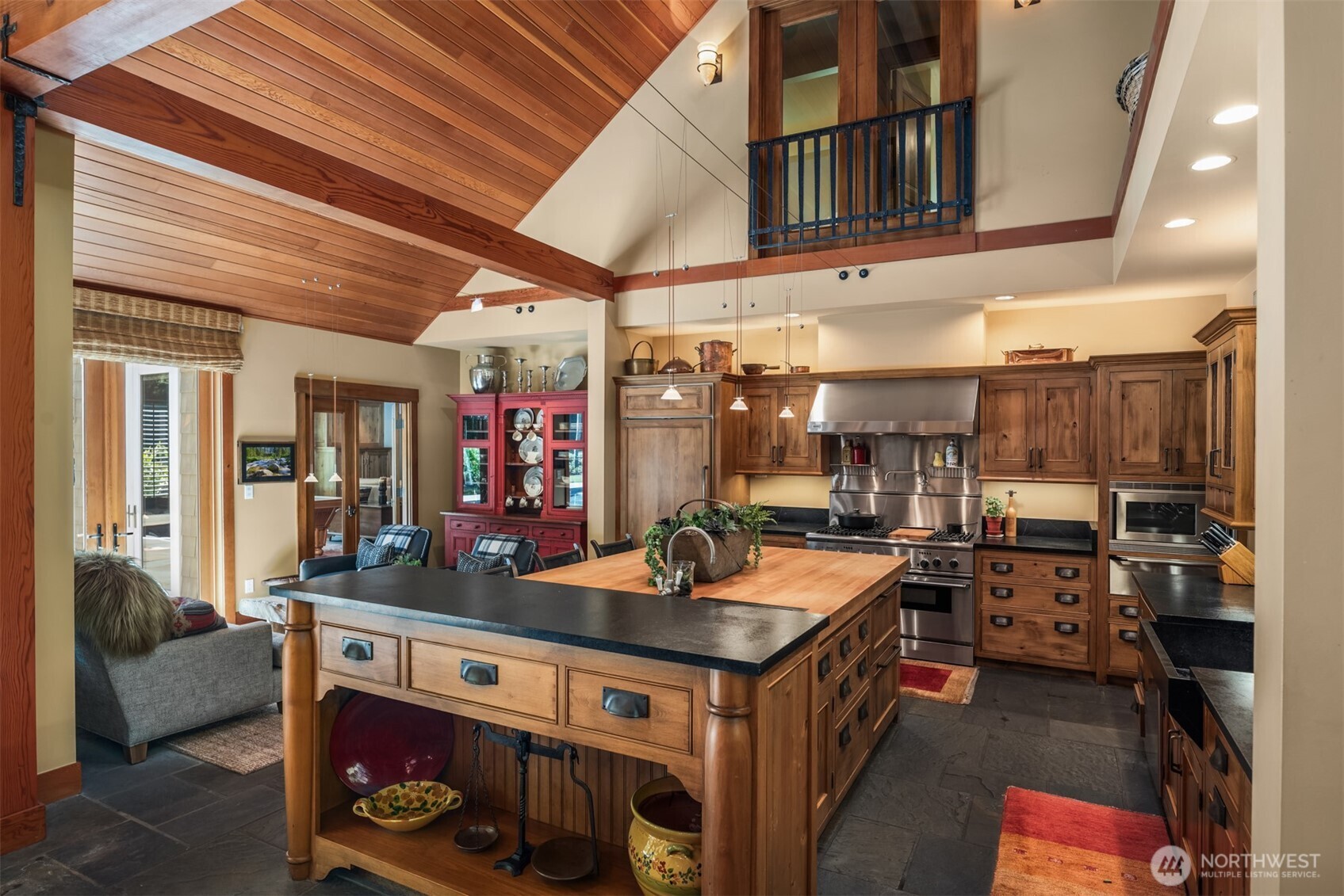 Kitchen with wood island, stainless range, and vaulted wood ceiling