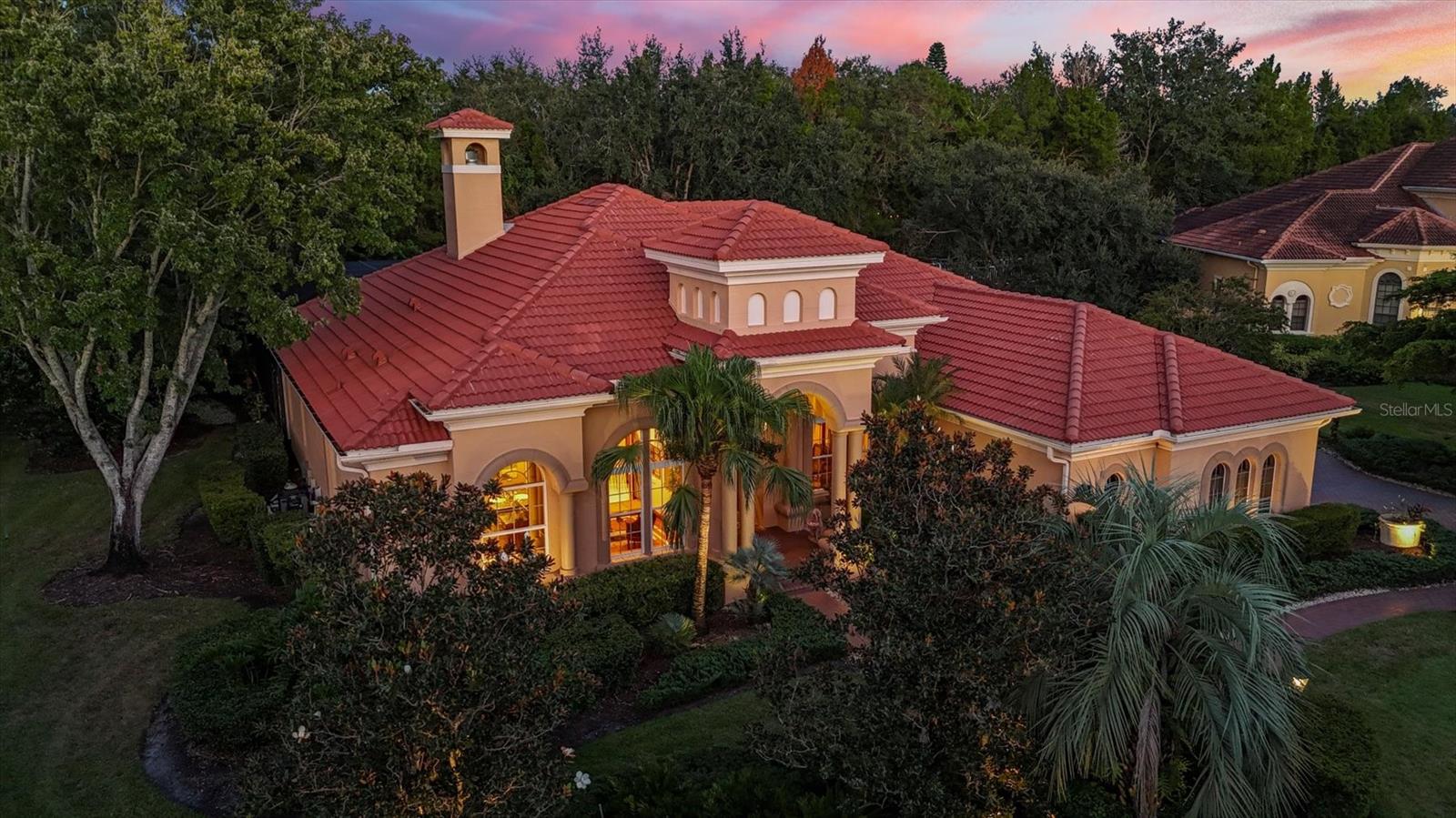 Glass double doors introduce this custom-built Arthur Rutenberg St. Augustine VI residence includes a new roof with a transferable warrantee installed in April 2025, a four-bedroom, 3.5-bath plus office retreat set on a private, beautifully landscaped lot on a cul-de-sac in the prestigious Lakewood Ranch Country Club. The foyer’s custom mosaic marble tile sets an elegant tone, leading to the formal dining room framed by a pillared entrance, tray ceiling and crown molding. The extended living room captivates with its 14-foot double tray ceiling, arched windows, detailed built-ins and an elegant gas fireplace. A pass-through with custom glass cabinetry and a wet bar connects to the main living areas, offering effortless flow for entertaining. The chef’s kitchen is a showpiece, featuring upgraded appliances including a built-in refrigerator, five-burner gas cooktop with hood and double ovens. Verde Uba Tuba granite countertops, custom cherry cabinetry with glass uppers, a large center island, and an additional prep island make this space functional and beautiful. The breakfast nook and adjoining great room feature custom built-ins, layered tray ceilings, and a full wall of sliding doors that open to the lanai, blending indoor and outdoor living seamlessly. Go outside to the extended lanai with extended dome-shaped enclosures, designed for relaxation and entertaining. Enjoy the heated pool and spa, a full summer kitchen with grill and beverage center, and granite counter seating, all surrounded by lush landscaping. The home’s ideal sun exposure provides the ideal mix of shade and light, offering breathtaking sunsets and year-round enjoyment. The primary suite is a private sanctuary featuring tray ceilings, crown molding, designer window treatments, plush upgraded carpet and dual custom walk-in closets. The spa-inspired marble-floored bath offers dual marble vanities, a walk-in shower with anti-slip floor, and a luxurious whirlpool soaking tub. Two beautifully appointed guest suites share a spacious full bath, providing comfort and privacy for family or visitors. The expansive bonus room offers flexible use as a fourth bedroom, media room or fitness space, with sliding doors that open directly to the lanai, creating a smart connection to the home’s outdoor oasis. A large private office features engineered hardwood floors with a custom inlay, French doors and large windows that fill the space with natural light. A convenient half bath is nearby. Additional highlights include a new whole-house water filtration system, tankless water heater, upgraded electrical panel servicing the pool, outdoor lighting and sprinkler system, along with an oversized side-load garage featuring upgraded storm doors and ample space for vehicles, golf carts and storage. In the gates of the renowned Lakewood Ranch Country Club, residents enjoy a lifestyle defined by luxury and leisure. The community offers championship golf courses, a state-of-the-art fitness center, tennis and pickleball courts, and an elegant clubhouse with fine dining and year-round social events. Manicured landscapes, scenic walking trails and proximity to Lakewood Ranch Main Street, Waterside Place and the area’s top beaches make this an extraordinary place to call home.