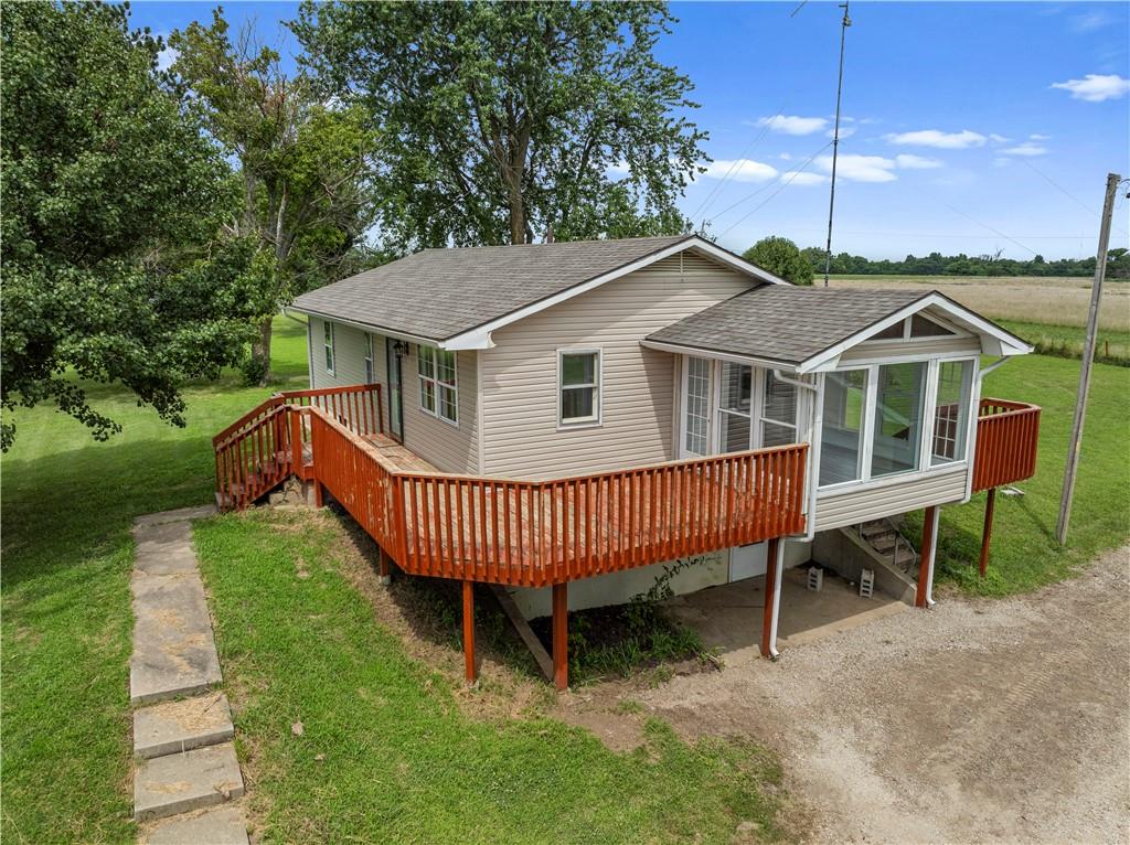 Need space, quick highway access, and room to make it your own? This 4-bedroom, 2-bathroom home—including 2 non-conforming bedrooms in the walk-out basement—is located just outside the Nevada, MO city limits with blacktop frontage and less than a mile from I-49.

Fresh updates include LVP flooring, newer carpet, and fresh interior paint throughout. The main level offers two conforming bedrooms and both full bathrooms, including a private ensuite off the primary bedroom.

The lower level walk-out basement features two additional non-conforming bedrooms and bonus space perfect for storage, hobbies, or guests. Kitchen appliances stay, and the bright sunroom provides the perfect spot to relax or create.

Outside, enjoy a wrap-around front deck, vinyl siding, central heat and air, and a 2-car detached garage.
This property blends comfort, location, and potential—schedule your showing today!