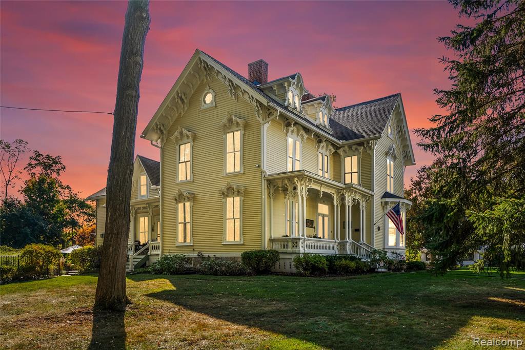 Welcome to one of Romeo’s most iconic homes - 261 Church Street - an exquisitely preserved Italianate residence perched on the highest point in the village.  From its elevated setting, this home offers commanding views and timeless charm, surrounded by mature trees, manicured gardens and the character that makes Romeo living so special. Nestled on nearly an acre, this corner lot property has century-old trees, three inviting porches, large patio, and in-ground heated pool for entertaining.   Rounding out the outdoor amenities is a historic carriage barn with large first level and upper hayloft with plenty of space for storage or fun.  The inside the home features 10-foot ceilings, 2 staircases, antique light fixtures, original wood shuttered windows, handcrafted detailed woodwork, hardwood floors, soapstone fireplace in the parlor, huge office with built-in library shelves, large great room and formal dining room, 1st floor laundry, 3 full baths: including the main floor bathroom with pressed tin walls and ceiling surrounding a claw foot tub.  Kitchen with dining nook and gas fireplace, 4 large bedrooms with spacious closets.   All of this just a short stroll from Romeo schools, charming downtown shops, dining and festivals.  All you need to do is move in and enjoy this well-maintained historic home:  New pool heater 2021, pump 2024 and liner 2025; new roof (rubber and shingle) with exterior chimneys refurbished 2012; new furnace/boiler 2023 and new water heater 2021.
**Excluded in the sale of the home: 3 mounted wall shelves in 2 bedrooms: tv and mount, speakers and brackets clock in dining room**