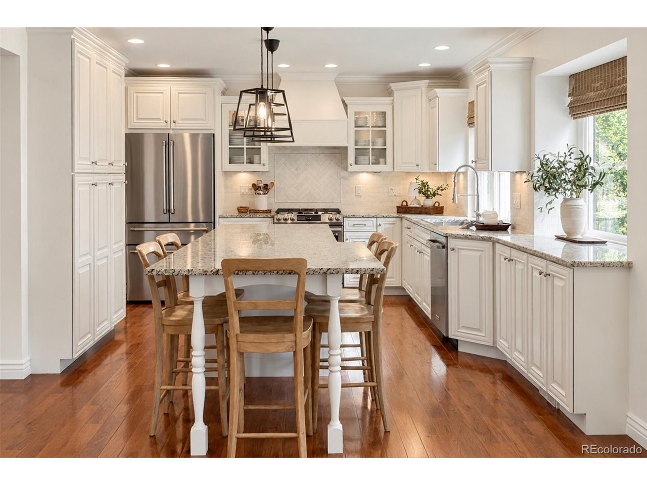 Welcome into this beautifully updated 5-bedroom, 4-bathroom two-story home! Crisp white painted brick, board-and-batten accents, black carriage lights, and mature shade trees give the home instant curb appeal with a timeless modern-farmhouse look.Inside, rich hardwood floors flow through the main level to a chef's kitchen at the heart of the home. You'll find classic white raised-panel cabinetry, glass-front uppers, and granite countertops, plus a gas range framed by a marble herringbone accent and a custom hood. The oversized island has turned legs and seating for six, with stainless appliances, iron lantern pendants, and a sunny window over the sink completing the space. The adjoining family room centers on a brick fireplace with built-in shelving. A wet bar with a dual-zone beverage and wine fridge makes entertaining easy, and sliding doors open straight to the backyard.The finished basement adds a spacious rec room with a second bar, plus a dedicated workout room/5th bedroom and plenty of flexible space for media, guests, or hobbies.Outdoors is a true retreat. A covered patio with a modern louvered pergola and integrated lighting frames a gas fire table lounge. Beyond it, a private fenced yard offers lush lawn, and a raised stone-walled terrace with a fire pit for evenings under the Colorado sky.Membership is available at The Club at Foxridge, where you'll enjoy neighborhood recreation and community amenities just minutes from home. This one has it all. Schedule your showing today!