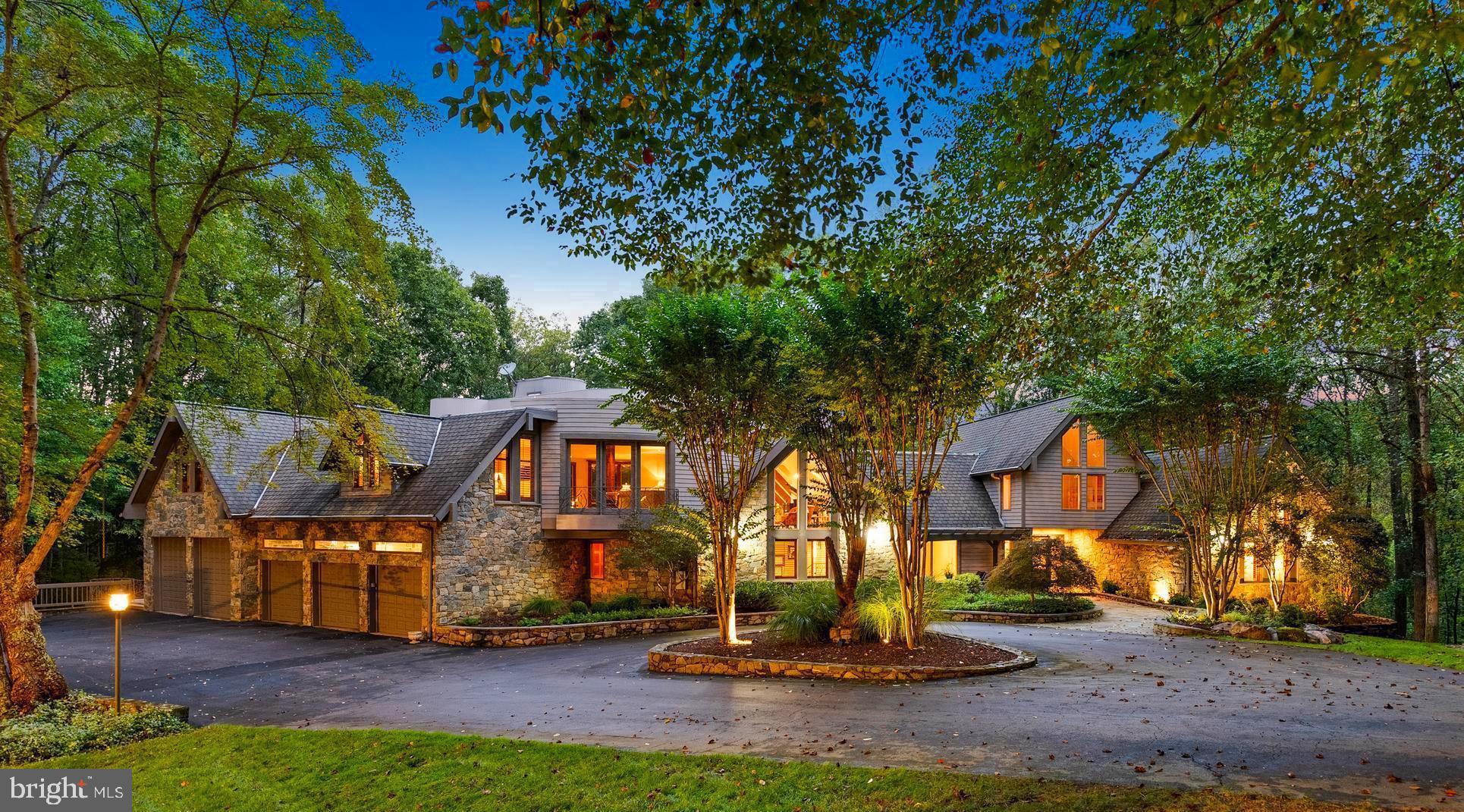 Welcome to the best of Aspen in Great Falls! Enter through the gates to a spectacular setting sited on 6 verdant acres and drive down the circular driveway to find a private resort with stack stone hardscape, lawn art and mature landscaping.  Light-filled Grand Foyer.  Hand-forged Cardine Studios custom iron railings, exposed wood beams and stone fireplaces throughout.  Gourmet Kitchen with Thermador/SubZero appliances, spacious island, big picture window with scenic, wooded vistas and a balcony that  overlooks a fabulous pool and pond.  An adjacent morning room with stone terrace doubles as entertaining or study space. Expansive A-Frame family room with beams, fireplace, and multi-level deck access. Main level includes second Owner’s suite with luxe bath, Au-Pair/In-Law, luxurious laundry with stone accents, grand great room with fireplace and soaring ceilings. Upper level Owner’s suite features balcony, custom beverage center, two extra large walk-in closets and spa-like primary bath with heated floors, soaking tub and steam shower. Spiral staircase leads to rooftop sundeck with 360-degree views. Three additional Bedrooms with updated baths. Lower level offers multi-person office with conference area, wine tasting room, ventilated Cigar room, full Bath, IT room and workshop. Club level entertainment space with paneled Bolivian Rosewood includes game areas, professional bar, billiards, and Caterer’s kitchen.  Gym with “environmental bed” with steam, sauna and sun lamp. Oversized heated 5-car garage with lift. Resort-like grounds feature infinity pool/spa, multi-level decks,  slate patios, pickleball/sport court with basketball hoops and wooded seclusion.