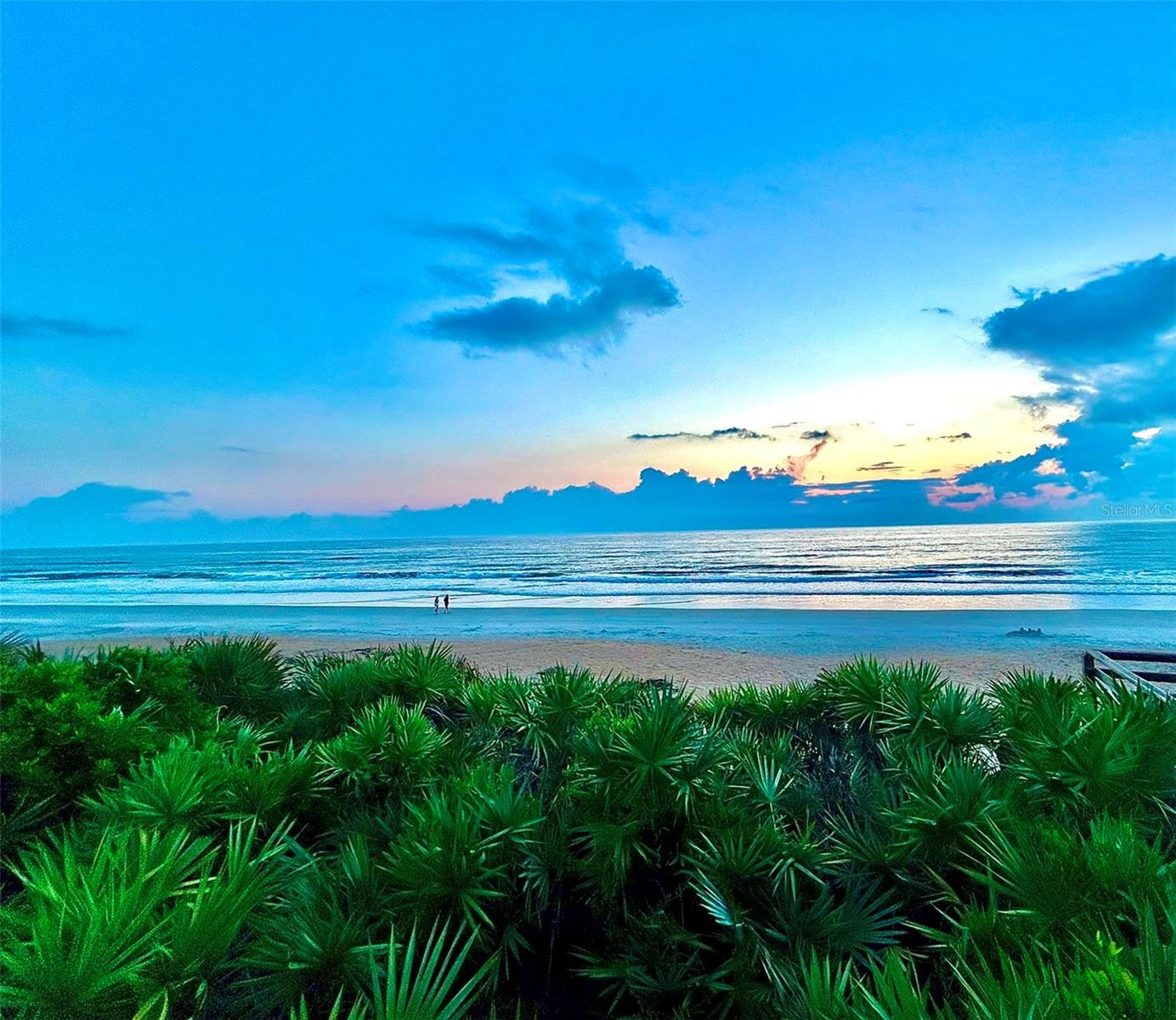 Imagine waking up each morning to the soft hues of sunrise over the Atlantic Ocean, visible from your wrap-around balcony in this beautiful 2-bedroom, 2-bathroom, direct oceanfront condo. Located on the coveted No Drive Beach of South New Smyrna, this unit offers panoramic views of miles of pristine coastline. The interior has been thoughtfully furnished with a coastal design and an open-concept living area drenched in natural light. The primary suite offers a serene retreat with a king-size bed, a large ocean-viewing window, and an elegant en-suite primary bathroom. A spacious guest bedroom and guest bathroom provide comfort and convenience for visitors. The unit also includes a stackable washer and dryer and features neutral tile and luxury vinyl plank flooring with carpet in bedrooms to complete this retreat home. Shorehom By The Sea, renowned for its rental zoning, has recently undergone extensive renovations, including newly restored balconies, and hurricane-rated windows, sliders, and doors, making this complex one of the most updated in New Smyrna Beach. All assessments have already been paid. Additional amenities include a walk-in closet in the primary bedroom, an owner closet within the condo, a large shared storage area on the 5th floor, a gas grill for the complex, multiple outdoor showers, and new restrooms in the pool area. Residents also benefit from a full-time property manager on-site. As a resident, you'll enjoy private beach access, a heated pool for year-round enjoyment, and the peace of mind that comes with a meticulously maintained property. Located minutes from the vibrant dining and shopping experiences of Flagler Avenue and Canal Street, and just a short drive from Canaveral National Seashore, this condo offers the perfect blend of luxury, convenience, and potential for lucrative rental income. Don't miss your chance to own a piece of paradise; this stunning beachfront retreat won't last long.