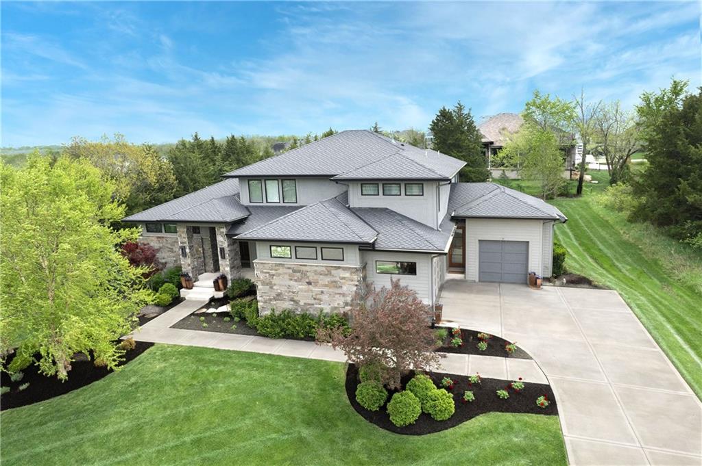 Welcome to this stunning 1.5-story custom home in the heart of Cedar Creek, offering over 4,500 square feet of luxury and thoughtful design. The main level features a spacious primary suite, private study, and a dedicated playroom—all seamlessly integrated for functional living. The chef’s kitchen is a true standout, boasting a built-in Sub-Zero refrigerator, Thermador double ovens, and a gas cooktop, perfect for entertaining or everyday gourmet cooking. The modern living room impresses with a dramatic floor-to-ceiling wood-paneled fireplace wall, flanked by built-ins and double sliding glass doors that open to a screened-in patio and dining space—ideal for indoor/outdoor living. Upstairs, you’ll find a sunlit loft with a skylight and three generous bedrooms, each with direct bathroom access. Enjoy resort-style living with unmatched neighborhood amenities including three community pools, tennis and pickleball courts, a clubhouse, basketball court, walking trails, and a catch-and-release fishing pond. Don’t miss your chance to own this incredible home in one of Olathe’s most sought-after communities!