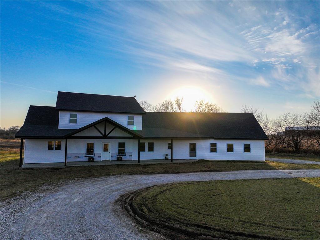 Searching for a spacious new build with acreage in Lamar, Missouri? This impressive 5-bedroom, 3-bath home sits on 43.56± scenic acres just off V Highway, offering sweeping views of open pasture and wooded countryside. The 2,400 sq ft residence is thoughtfully designed with generous living space, and covered porches perfect for enjoying quiet country mornings and sunsets. A massive 1,500 sq ft attached garage provides ample room for vehicles, equipment, or a workshop setup, making the property as functional as it is beautiful.The home is currently awaiting electrical installation and interior finishes, giving the future owner a rare opportunity to customize the final details to match their style and needs. Major construction has already been completed, saving significant time and expense while still allowing creative control over finishes, layout touches, and design choices. Combined with the privacy and versatility of the surrounding acreage, this property presents an exceptional opportunity to create a custom country estate tailored exactly to your vision.The home is served by rural water and lagoon system and requires only an electrical hookup to be fully functional. Located in the Lamar School District in Barton County, Missouri, this diverse 43± acre property offers an excellent mix of recreation and agricultural potential. A large stand of mature timber provides prime wildlife habitat, while established pasture and cross fencing make the land ready for livestock. In addition, fertile tillable ground supports farming opportunities, and a year-round creek runs through the center of the property, adding both beauty and practical water access.