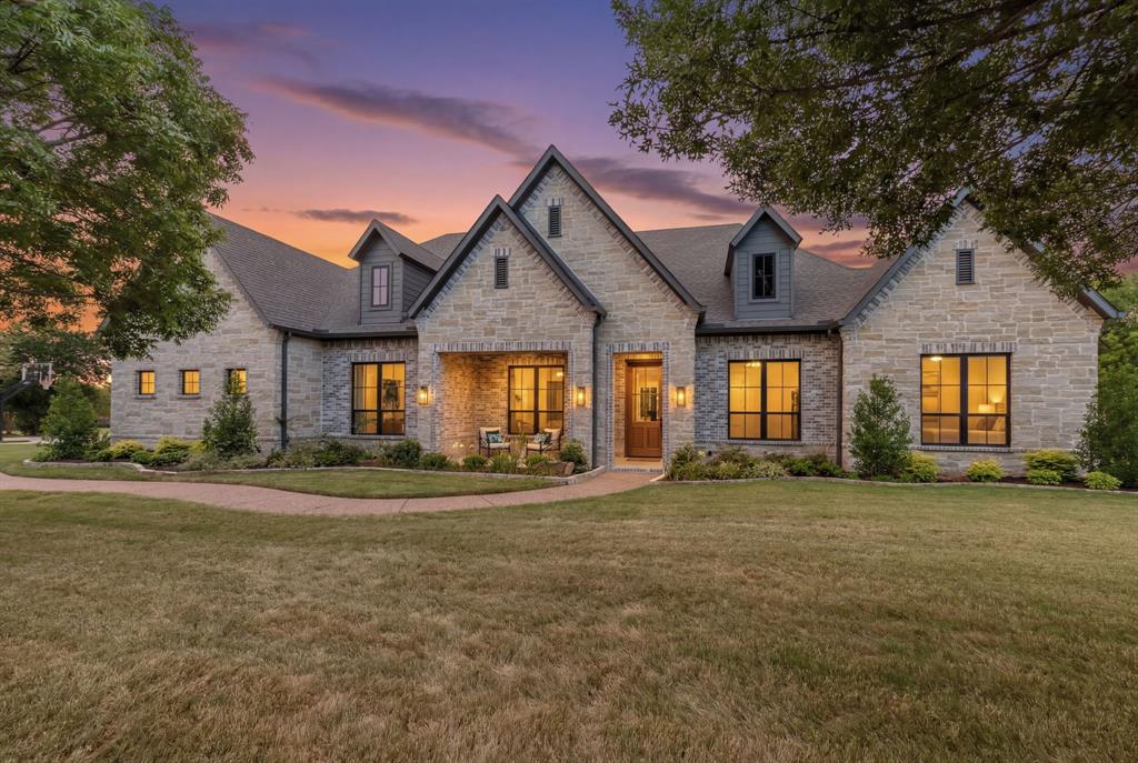 Completed in 2025 by Tim Jackson Custom Homes after a lightning strike destroyed the original home. Only the slab remained. See Seller's Disclosure. Lovejoy ISD home has 6 beds, 6.5 baths, a mahogany front door welcomes you into interiors highlighted by Andersen windows and solid white oak flooring throughout. The primary suite overlooks the backyard and features a tray ceiling and a spa-inspired bath with a soaking tub set within the oversized frameless-glass shower, dual shower heads, quartzite vanities, and custom his-and-her closets. 3 secondary bedrooms include private ensuite baths, while 2 more share a connected bath in a separate guest wing, well suited to multigenerational living or extended stays. The kitchen is equipped with premium JennAir appliances and refrigerator, Bosch dishwasher, quartzite countertops, and custom full-overlay cabinetry. The butler's pantry includes a second fridge, second dishwasher, microwave, and prep sink. The kitchen flows into the dining room, formal living room, and family room, creating an ideal setting for entertaining. Additional first-floor features include an executive office, oversized laundry room with mudroom storage, utility sink, and Costco closet. The family room is anchored by a floor-to-ceiling stone fireplace, wood mantel, and ceiling beams. The downstairs flex room features built-in cabinetry and is adjacent to a full pool bath with direct backyard access. Upstairs offers an additional bedroom with ensuite bath and a gameroom with built-ins, walk-in closet, and half bath. Outdoor amenities include a resort-style waterfall pool and spa, tanning ledge, firepit, covered patio, and pavilion with stone fireplace, outdoor kitchen, built-in grill, sink, and seating area. The grounds also include a fenced play yard and basketball court with pickleball lines. Mature privacy trees line the rear of the property. Near the Heard Natural Science Museum, this property offers luxury living and exceptional entertaining spaces.