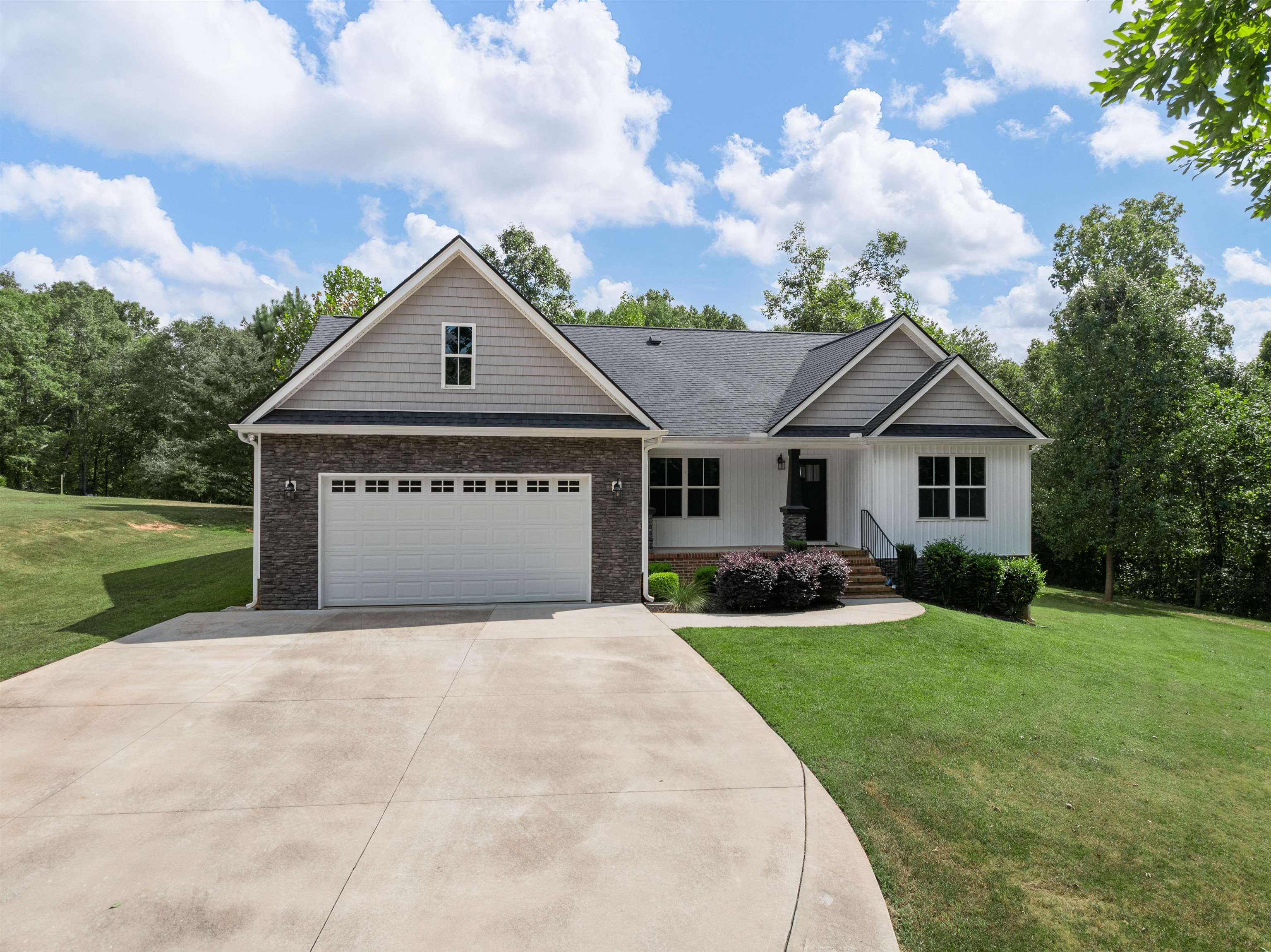 Approximately 5.85 acres of privacy, recreation, and convenience await with this custom-built home, just 6 years young, in the highly desirable Five Forks area. Offering a rare combination of modern comfort and outdoor living, this property is truly one of a kind.  The current owner has extensively enhanced the grounds with nearly 700 tons of dirt, 226 tons of gravel, and 30+ pallets of sod, creating a manicured, picture-perfect setting. The Enoree River borders the property, providing opportunities for fishing, floating, hunting, or simply enjoying peaceful walks along wooded trails that lead to a fire pit by the river. An oversized driveway and parking pad—wide enough for more than three vehicles—plus an additional gravel pad make it easy to park RVs, boats, or other recreational vehicles. The garage includes an 8-foot door for larger vehicles, while a fenced area is perfect for pets, chickens, or small livestock. The property also qualifies for Spartanburg County’s Agricultural Tax Credit (application required by new owner).  Inside, the open floor plan showcases vaulted ceilings, custom beams, and stylish focal walls, including a welcoming foyer accent wall. The kitchen features an oversized island, subway tile backsplash, extensive custom cabinetry with soft-close drawers, granite countertops throughout, and a gas stove/range (also pre-wired for electric). The spacious primary suite includes a tray ceiling with a designer focal wall, while the luxurious tiled shower offers multiple shower heads and a built-in seat. All bedrooms are generously sized—an uncommon find in today’s market. Additional upgrades include waterproof Pergo flooring, a stone propane gas fireplace, and granite counters in every bath.  Outdoor living shines with a large covered deck and an adjoining concrete patio, pre-wired for a hot tub, perfect for entertaining or relaxing. The non-smoking, pet-free interior reflects meticulous care and pride of ownership.  Located just 4 minutes from Woodruff Road, 10 minutes from GSP Airport, 12 minutes from BMW, and 20 minutes from Downtown Greenville, this property combines peaceful country living with unmatched convenience.  Don’t miss your chance to own this Five Forks gem—schedule your private showing today!