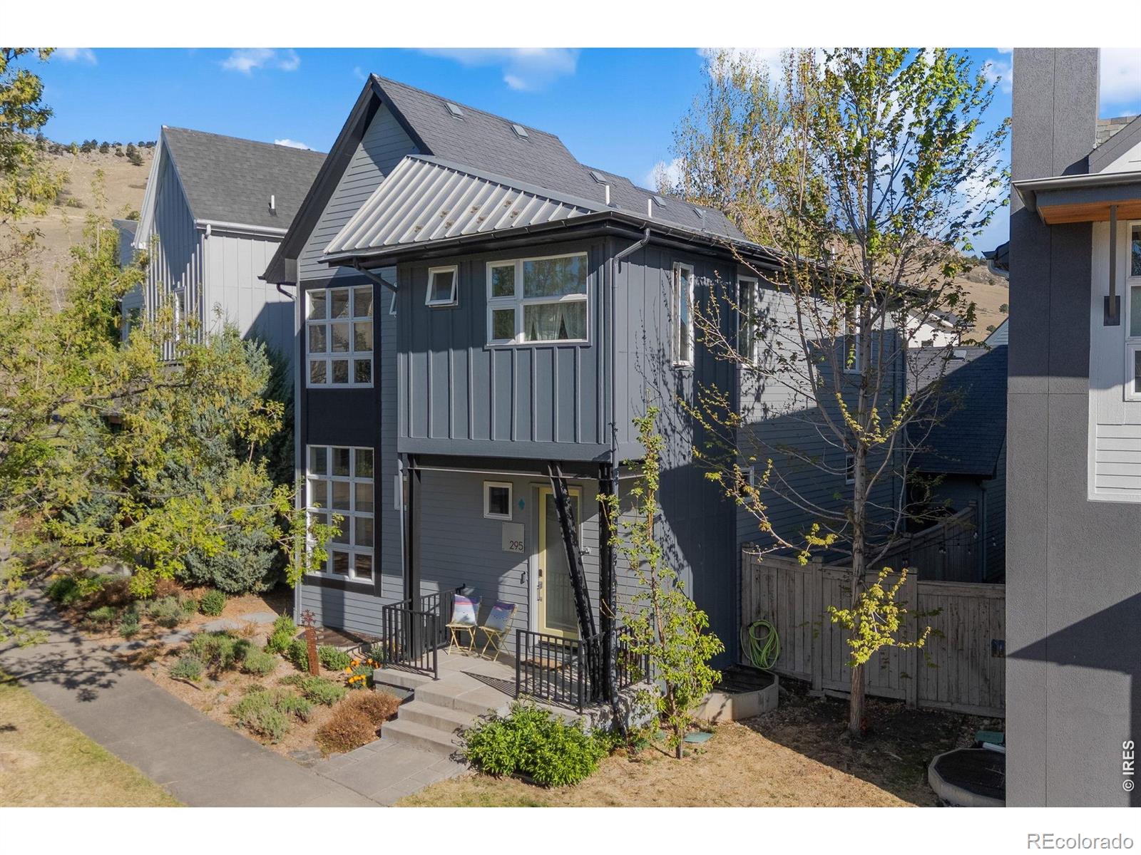Welcome to turn-key living in Dakota Ridge, one of North Boulder's most sought-after neighborhoods. Perfectly positioned a half block away from Boulder's premier trail system, this home offers seamless access to everything the city has to offer - whether you're heading out for a morning hike or a night on the town. Striking modern architecture with soaring floor-to-ceiling windows that flood the open floor plan with natural light and mountain views, creating an inviting atmosphere you'll love coming home to. The spacious living and dining areas flow effortlessly to a private deck complete with a gas fireplace - ideal for year-round entertaining. The open-concept kitchen keeps you connected to your guests while you cook, making every gathering feel effortless. Upstairs, plush new carpet adds a fresh, cozy feel throughout. Retreat to the luxurious primary suite with large windows highlighting gorgeous mountain vistas and a five piece bath with an oversized soaking tub framed by mature trees and views - your own private sanctuary. Two additional bedrooms and a full bath provide flexible space for family, guests or a home office. The finished lower level offers a generous recreation room perfect for movie nights or game days, plus an additional bedroom and full bath - ideal for multi-generational living or an au-pair suite. A spacious two-car garage with ample storage is a rare find at this price point in Boulder, keeping your vehicles and gear protected through every season. Practical upgrades including a new metal/shingle roof and ADT/Google Home security system provide lasting peace of mind. Life in Dakota Ridge comes with access to a vibrant community center featuring party spaces, gathering areas, and fire pits. Commuting is a breeze with a Broadway bus stop nearby and dedicated bike paths leading straight to downtown Boulder. This is exceptional style and value in North Boulder - don't let it pass you by.