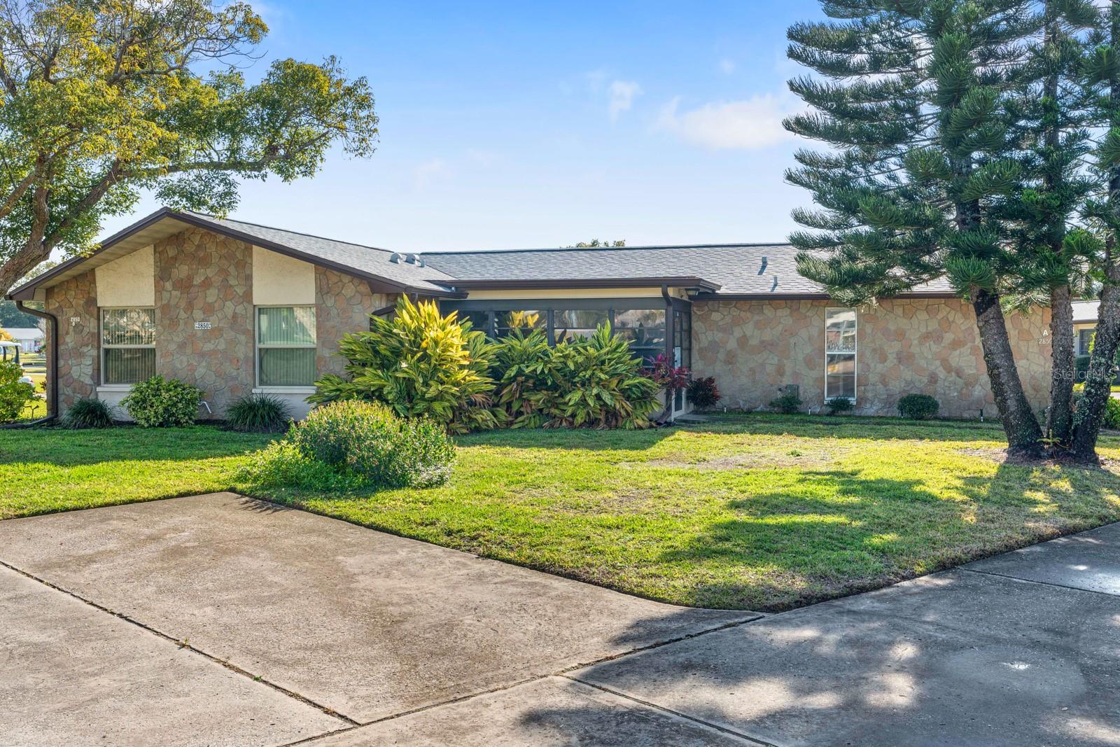 Welcome to effortless Florida living in this furnished villa-style condo offering 1,000 square feet of living space, situated on a desirable corner lot. Move-in ready and thoughtfully laid out, this home features 2 bedrooms, 2 bathrooms, and a comfortable living and dinette area filled with natural light. The open kitchen prep area overlooks the living space, creating an easy flow for everyday living and entertaining. Sliding glass doors lead from the living room to an enclosed lanai, perfect for relaxing or enjoying the Florida lifestyle year-round. The spacious primary suite includes a large walk-in closet and a private bath with a walk-in shower. Laundry hookups are conveniently located in the attached one-car garage.Major improvements include a brand-new 2024 roof and a 2018 HVAC system, offering added peace of mind. Neatly landscaped surroundings enhance the home’s curb appeal. Located in the sought-after Highland Lakes 55+ community of Pinellas County, residents enjoy resort-style amenities including three executive 9-hole golf courses, multiple swimming pools with a geothermal-heated Olympic-size pool, and courts for tennis, pickleball, bocce, and shuffleboard. Additional highlights include a clubhouse, a lakeside lodge on Lake Tarpon, pontoon boat excursions, an arts and crafts center, a woodworking shop, and RV/boat storage with launch access, along with an active calendar of clubs and social events. Conveniently positioned just minutes from grocery stores, shopping, dining, medical facilities, US-19, and the Gulf Coast beaches, this villa offers exceptional value, lifestyle, and location. Schedule your private showing today.