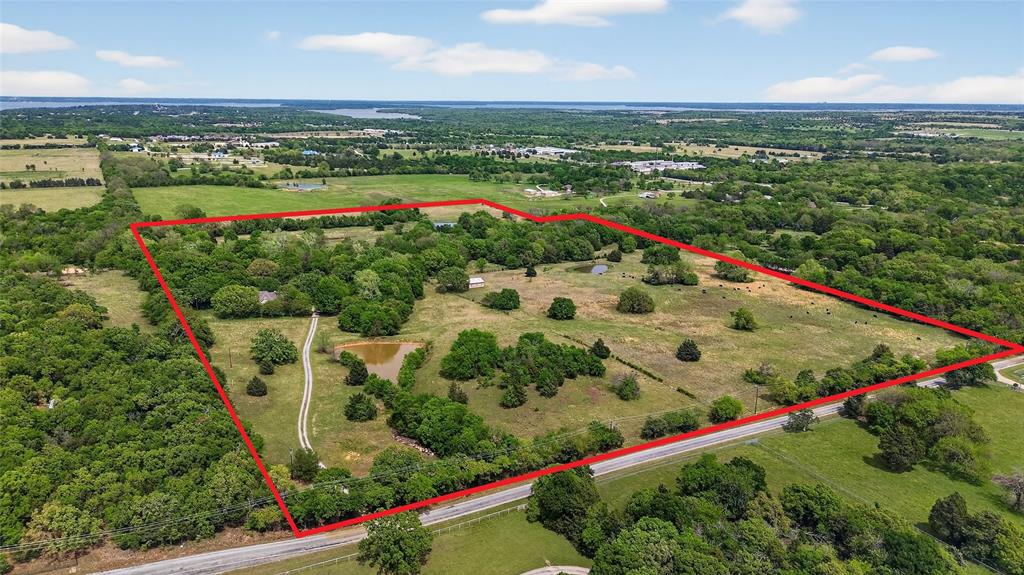 Seven Oaks Ranch - 59 acres near Lake Texoma -3 ponds - Creek bed - Morton barn - Black pipe fencing - Mature oaks - Ag-exempt ranch retreat.Welcome to Seven Oaks Ranch, an exceptional 59-acre retreat just minutes from Lake Texoma, where privacy, functionality, and timeless Texas beauty come together.A scenic drive begins along peaceful Cemetery Road, leading to the black pipe fenced entrance with cattle guards at both the main gate and private home entrance, creating a polished first impression that sets the tone for the ranch lifestyle this property offers. Set well back from the road beneath towering mature oaks, the custom one-story home is positioned in a peaceful and secluded setting.A large creek bed winds through the ranch, framing scenic treed views, and is complemented by three ponds that enhance both the beauty and utility of the property. The blend of mature trees, open grazing land, and water features creates a classic Texas ranch setting with abundant wildlife and endless opportunities to enjoy the outdoors.The Morton barn-building is ideal for tractor, equipment, and ranch storage, while also offering excellent potential to be adapted into a horse setup with stalls and tack space.Additional flexibility continues at the garage, which includes space for a shower or dog wash, ideal after muddy ranch days or lake outings. Above the garage, the floored attic space with its own bathroom offers strong potential for future guest quarters, bunk space, office use, or a game room.Whether for a full-time ranch residence, weekend escape near Lake Texoma, horse property, or long-term land investment with ag benefits already in place, Seven Oaks Ranch offers a rare blend of privacy, water, utility, and lifestyle.