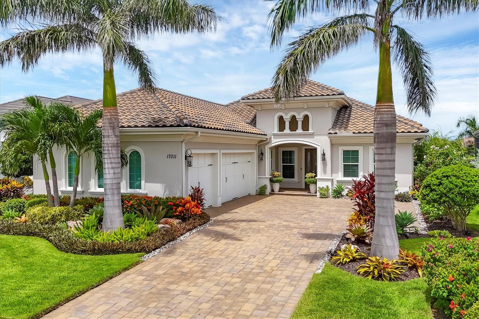 Positioned on a serene lake in the exclusive Lake Club, this beautifully appointed four-bedroom, four-bath plus office home combines luxury design with extensive upgrades for an unparalleled lifestyle. Lush landscaping and welcoming entryway set the tone, opening to a light-filled layout enhanced by designer lighting, custom blinds, 13-foot tray ceilings and sleek porcelain tile throughout. The state-of-the-art, fully custom kitchen is a chef’s dream, featuring custom cabinetry, quartzite countertops, farmhouse sink, pot filler and a 48-inch Fulgor Milano dual fuel range with six gas burners and dual electric ovens. A spacious island provides function and style, ideal for entertaining. Adjacent, the dining area and open great room showcase a striking custom wine bar with quartzite counters, wine refrigerator and dramatic glass cabinet wine wall. The primary suite offers a retreat, with custom dual walk-in closets and a spa-inspired bath complete with dual vanities, a makeup area, oversized walk-in shower and a custom Finnish sauna added in 2023. Two guest suites provide generous accommodations, each with en-suite baths featuring upgraded cabinetry, dual sinks and frameless glass showers. A highlight of the home is the four-season room with 11-foot impact-rated sliding glass walls, allowing effortless transitions between indoor comfort and outdoor living. This space is designed for year-round enjoyment, offering a ribbon fireplace, media wall, outdoor kitchen with flat top grill, professional burner, bar refrigerator, quartzite counters, and its own dedicated air conditioning system. The outdoor oasis, framed by a panoramic screen, is anchored by a saltwater pool added in 2022 with fire features, dual waterfalls and a step-down water element overlooking the lake. Additional features include a three-car garage with epoxy flooring and utility sink, a whole-home water purification system (2021), solid wood interior doors, and sound insulation in key areas. An optional furniture package is also available, making this residence turnkey if desired. As a resident of The Lake Club, you’ll enjoy exclusive amenities including a grand clubhouse with restaurant, resort-style and lounge pools, fitness center, spa services, tennis courts and a playground. This property exemplifies contemporary luxury living, blending modern upgrades with the natural beauty of its lakefront setting.