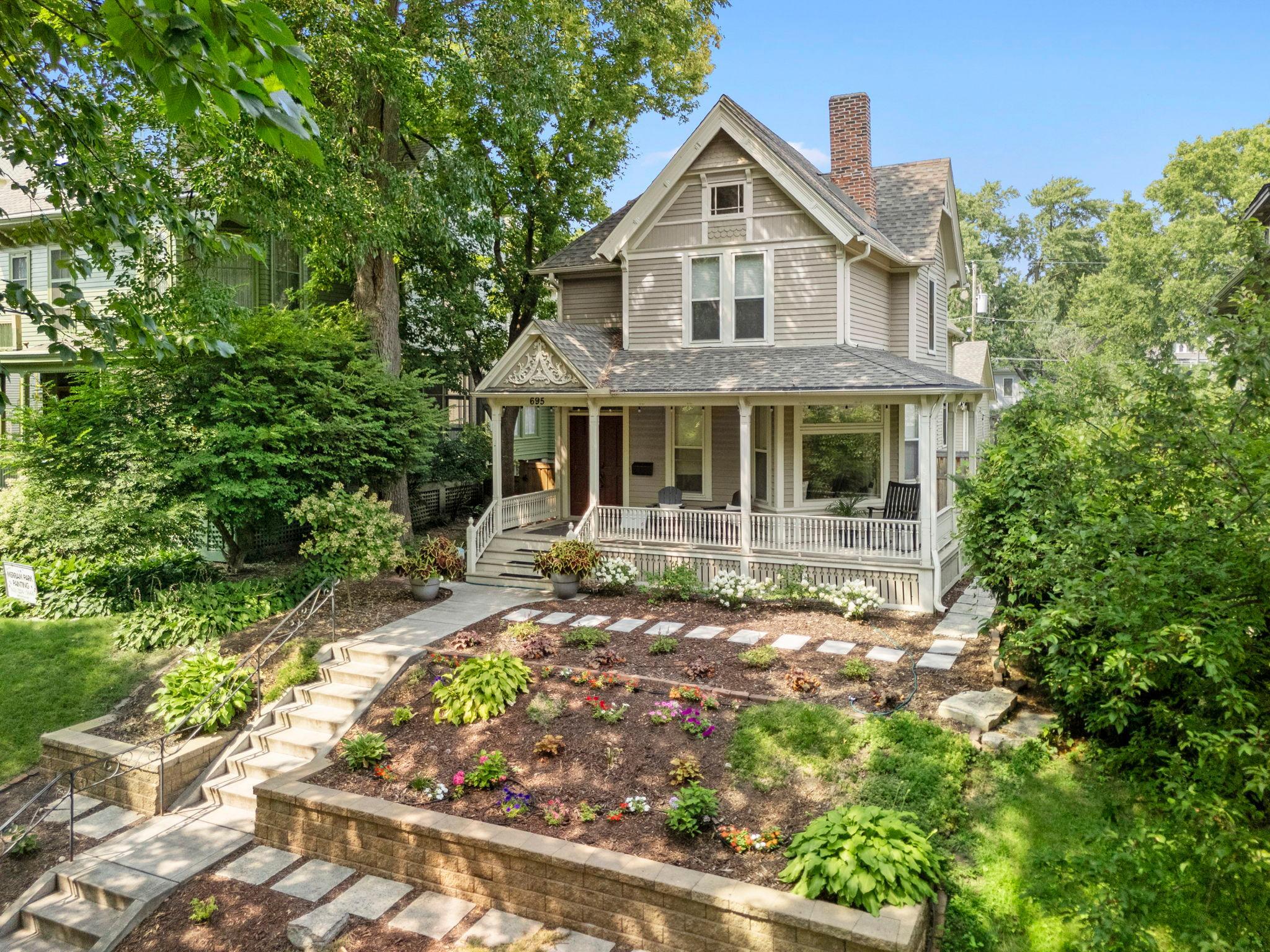 Welcome to this beautifully remodeled 4-bedroom, 3-bathroom 1880s home where modern updates blend seamlessly with timeless character. Exceptional curb appeal welcomes you with mature landscaping, terraced retaining walls, colorful gardens, and a charming wraparound porch. Inside, new hickory hardwood floors complement original crown molding and trim. The remodeled chef’s kitchen features granite countertops, center island, abundant cabinetry, stainless steel appliances including a Wolf dual-fuel cooktop & range, beverage station, beverage refrigerator, and 7x4 pantry incorporating the original dining room pocket door. The main level offers a spacious dining room, light-filled living room with bay window, inviting front sitting room with electric fireplace and built-in bench, versatile office/flex space with built-ins, and convenient half bath with heated floors. A large mudroom/laundry room features a front-loading washer and dryer, granite counter and sink, cabinetry, bench, and hooks with access to the backyard and detached 2-car garage. The fully fenced backyard provides privacy, extensive patio space, and raised garden beds. Upstairs, four spacious bedrooms feature original hardwood floors and ample closet space, including a beautiful primary suite with electric fireplace, built-ins, backyard views, dual closets, and access to an updated full bath with heated floors, oversized soaking tub, walk-in shower, dual sinks, and illuminated mirrors. A second ¾ bath serves the remaining bedrooms. The unfinished lower level offers excellent storage and future finishing potential. Despite its 1880s construction, the home offers the modern comfort of whole-house air conditioning. Additional updates include a new wood front door, tile entryway, iron front stair railing, carpeting on both staircases, and four new windows. Ideally located near Grand Avenue, with restaurants, bars, parks, shopping, and other amenities within walking distance. A wonderful blend of character, thoughtful updates, comfort, and convenience!