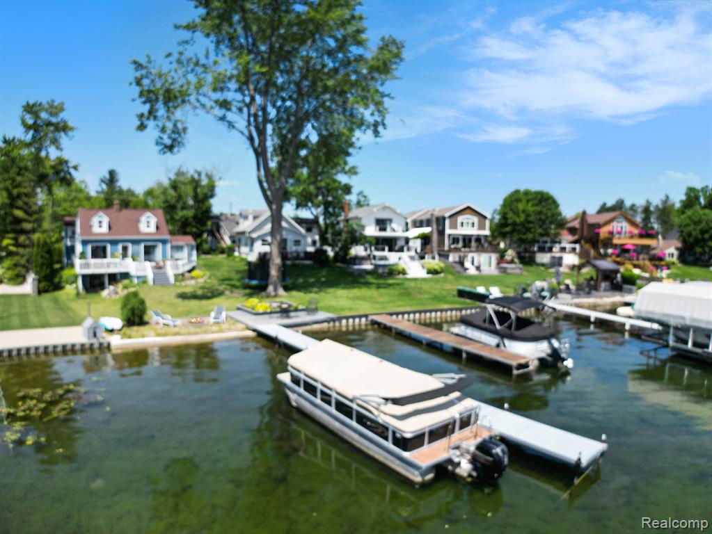 Enjoy lakefront living on sought-after all-sports Lake Fenton with this spacious and updated Cape Cod-style home offering 40 feet of private lake frontage. With over 2,600 square feet, this 4-bedroom, 2-bath waterfront home blends classic character with modern updates and the kind of setting that makes every day feel like a vacation. The main level features new luxury vinyl plank flooring and fresh paint (2021), creating a bright, refreshed interior. Natural light pours in through large windows and multiple skylights, highlighting the beautifully updated kitchen with stainless steel appliances and solid surface counters. The living room, anchored by a fireplace, offers serene views of the lake and easy access to the deck—perfect for entertaining or soaking in the waterfront setting. The upper-level bonus room above the garage is nicely finished, ideal for a home office, guest suite, or hobby space. A partially finished walkout basement includes a cozy fireplace and offers even more potential for living or entertaining. Additional improvements include an updated main floor bath (2022), a new well tank (2022), and new garage doors (2023). Outdoor features include a lakeside fire pit on your private beach, a spacious deck, and plenty of room to enjoy the water year-round. This home offers the rare combination of space, updates, and direct access to one of the area’s premier lakes—ideal for boating, swimming, or simply relaxing by the water.